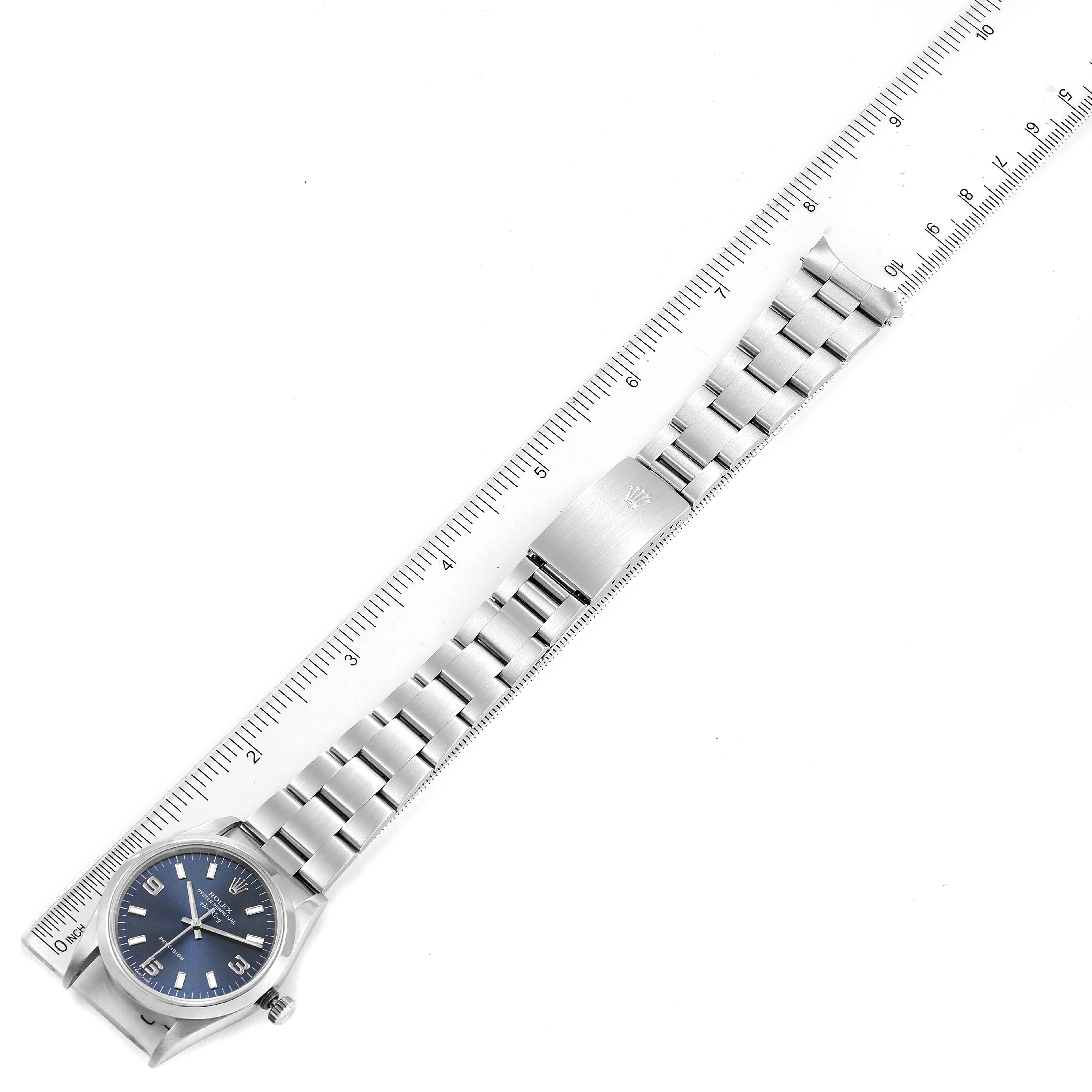 The image shows an overhead view of a Rolex Air-King 14000 Men's Stainless Steel Blue Dial 14000 Men's Stainless Steel Blue Dial watch emphasizing the face, bracelet, and clasp beside a ruler for scale.