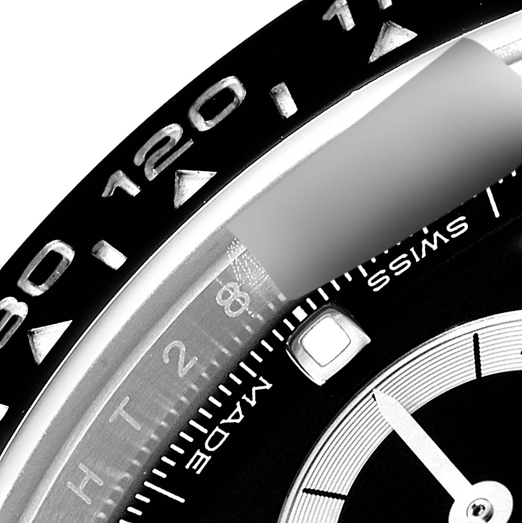 The image shows a close-up of the bezel and part of the dial of the Rolex Daytona 116500 Men's Stainless Steel Black Dial 116500 Men's Stainless Steel Black Dial watch.