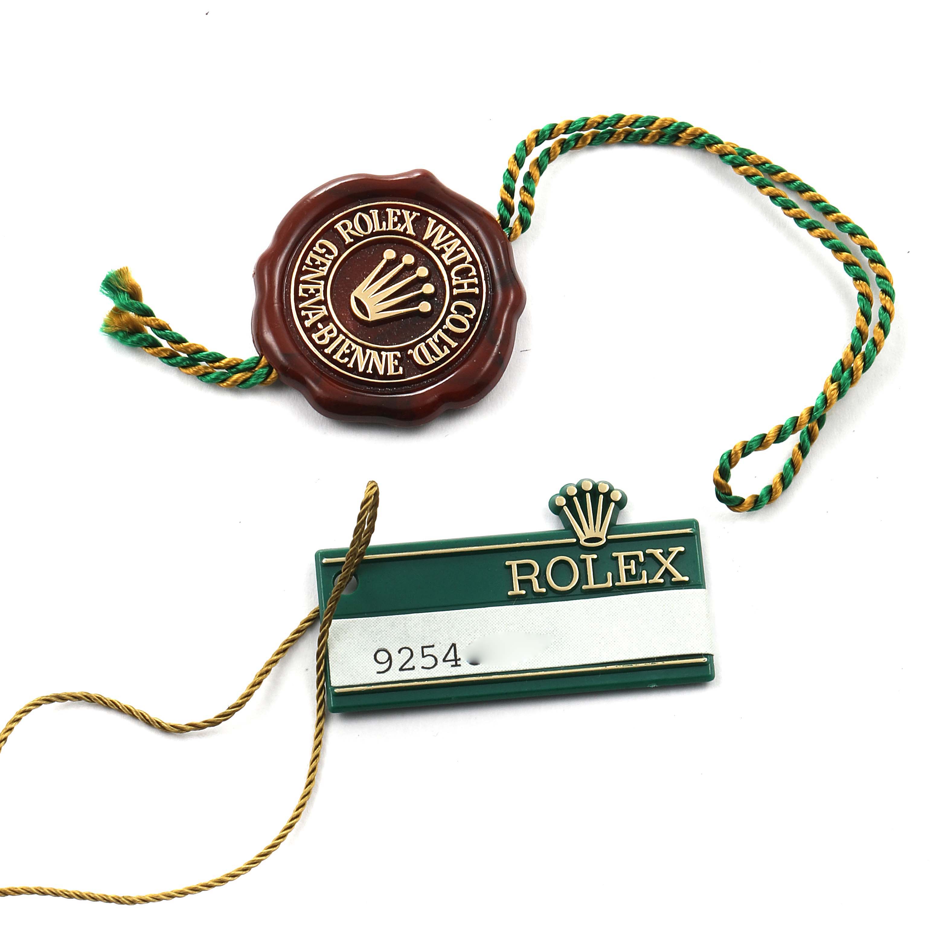 The image shows a Rolex Date 69160 Women
s Stainless Steel Blue Dial 69160 Women
s Stainless Steel Blue Dial model
s tag and seal from a top-down angle.