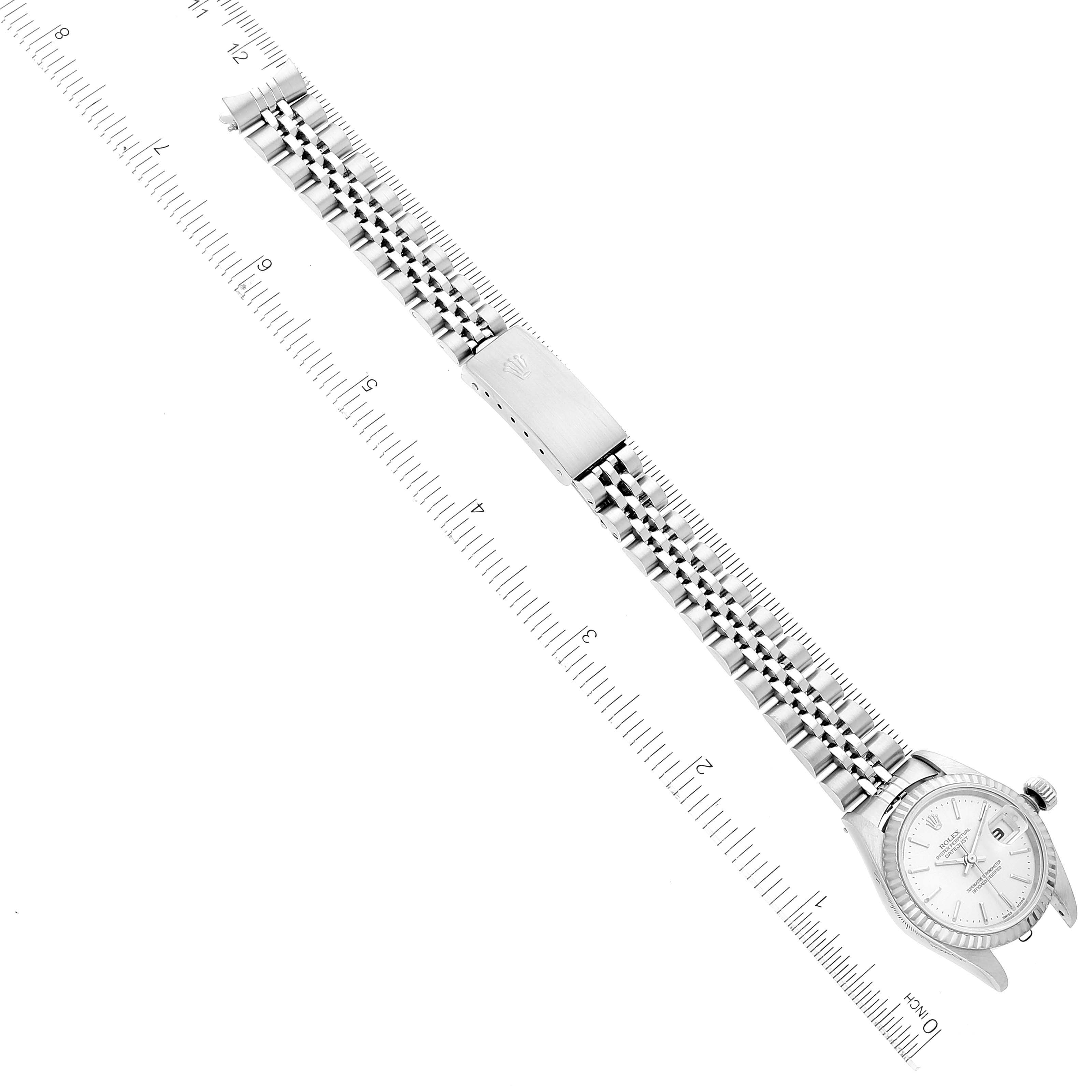 This top-down image features a Rolex Datejust 79174 Women's Stainless Steel Silver Dial 79174 Women's Stainless Steel Silver Dial watch displaying its face, bracelet, and clasp next to a ruler for measurement.
