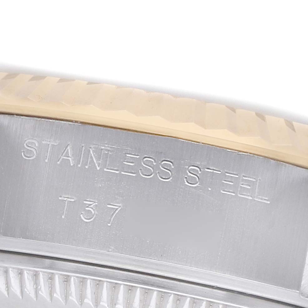 The image shows an angled close-up of the side of a Rolex Datejust 69173 Women's Stainless Steel Red Dial watch, featuring the stainless steel engraving on the case.