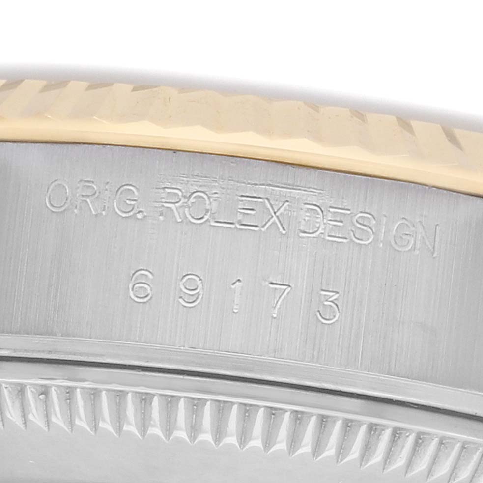 The image shows a close-up of the side of a Rolex Datejust 69173 Women's Stainless Steel Red Dial watch, highlighting the engraving and part of the bezel.