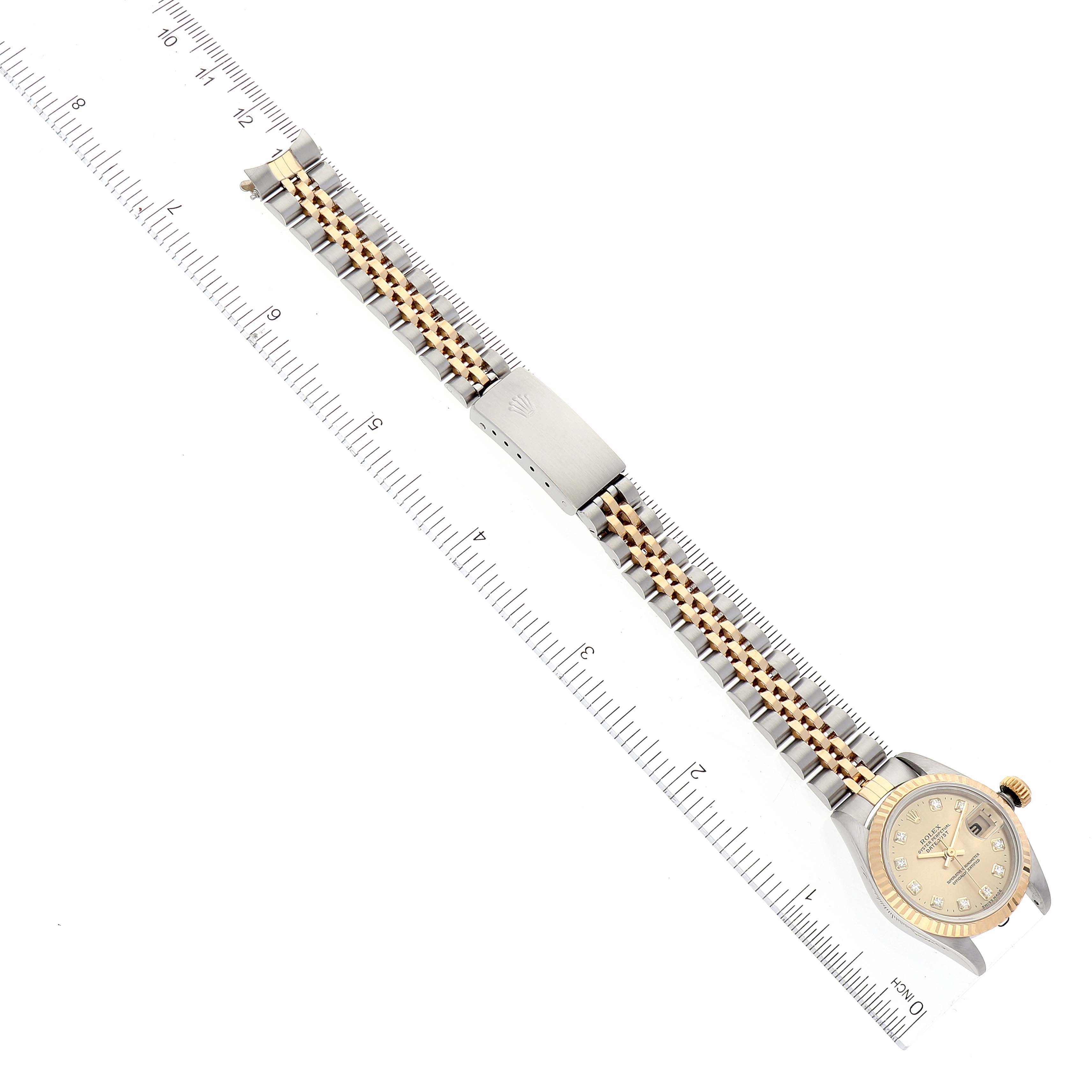 The image shows a top-down view of a Rolex Datejust 69173 Women's Steel and Gold (two tone) Champagne Dial 69173 Women's Steel and Gold (two tone) Champagne Dial watch with its full bracelet aligned with a ruler.