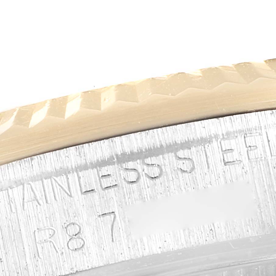 A close-up of the underside of the bezel and case of a Mid-Size Rolex watch, showing the "STAINLESS STEEL" engraving.