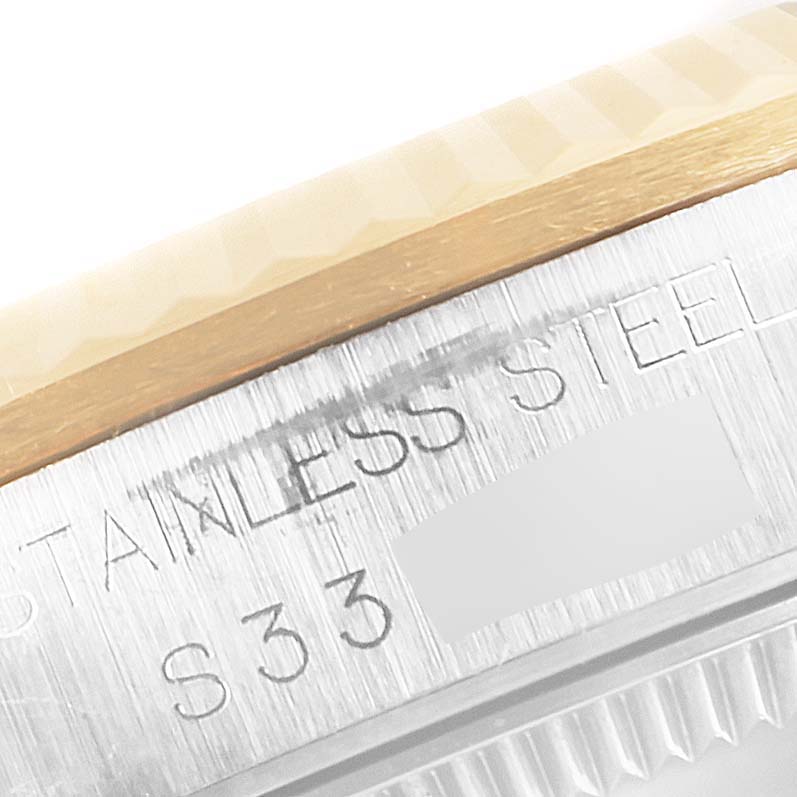 This image shows a close-up of the side of a stainless steel Rolex Mid-Size 68273 Women's Steel and Gold (two tone) Champagne Dial 68273 Women's Steel and Gold (two tone) Champagne Dial watch, highlighting part of the bezel and engraved text.