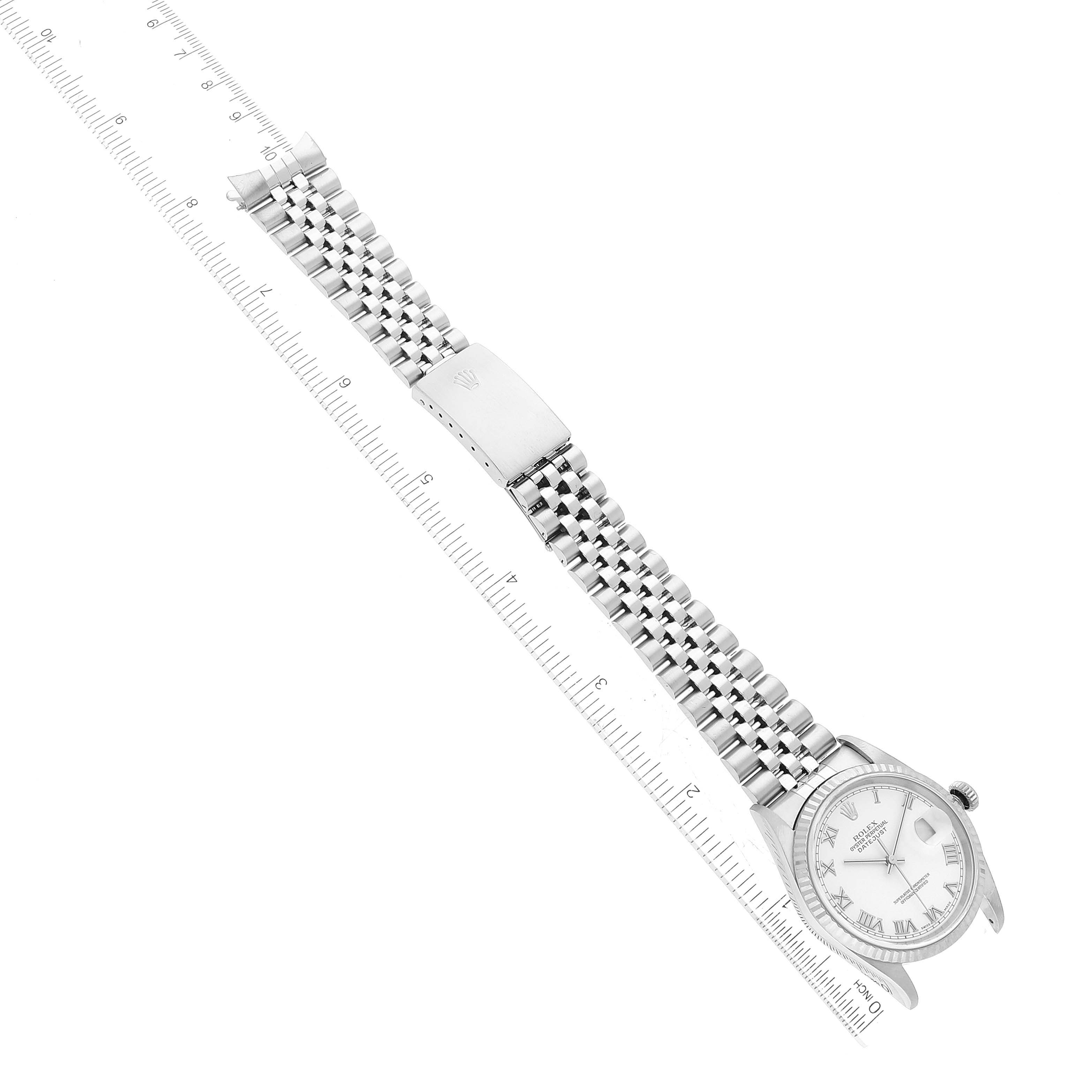 The image shows an aerial view of a Rolex Datejust 16234 Men's Stainless Steel White Dial 16234 Men's Stainless Steel White Dial watch, displaying its face, bezel, bracelet, clasp, and a ruler for scale.
