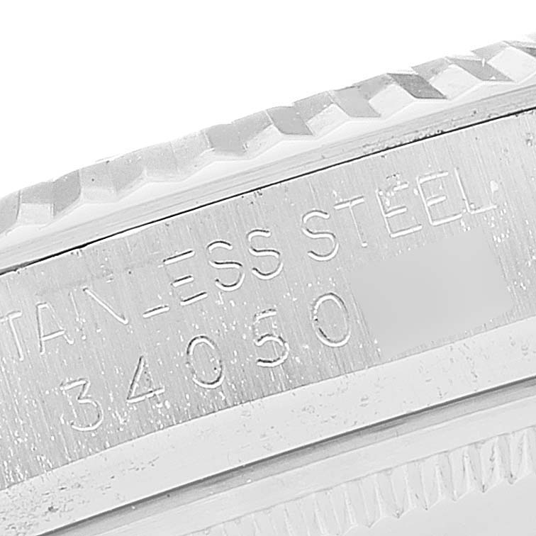 The image shows a close-up view of the fluted bezel and serial number engraving on a Rolex Datejust 1601 Men
s Stainless Steel Silver Dial 1601 Men
s Stainless Steel Silver Dial watch.