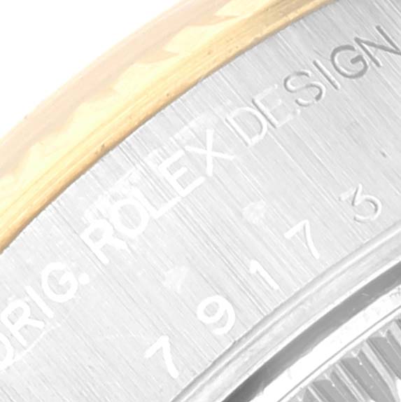 The image shows a close-up of the Rolex Datejust 79173 Women's Steel and Gold (two tone) Champagne Dial 79173 Women's Steel and Gold (two tone) Champagne Dial watch's edge and engraved original design serial numbers.