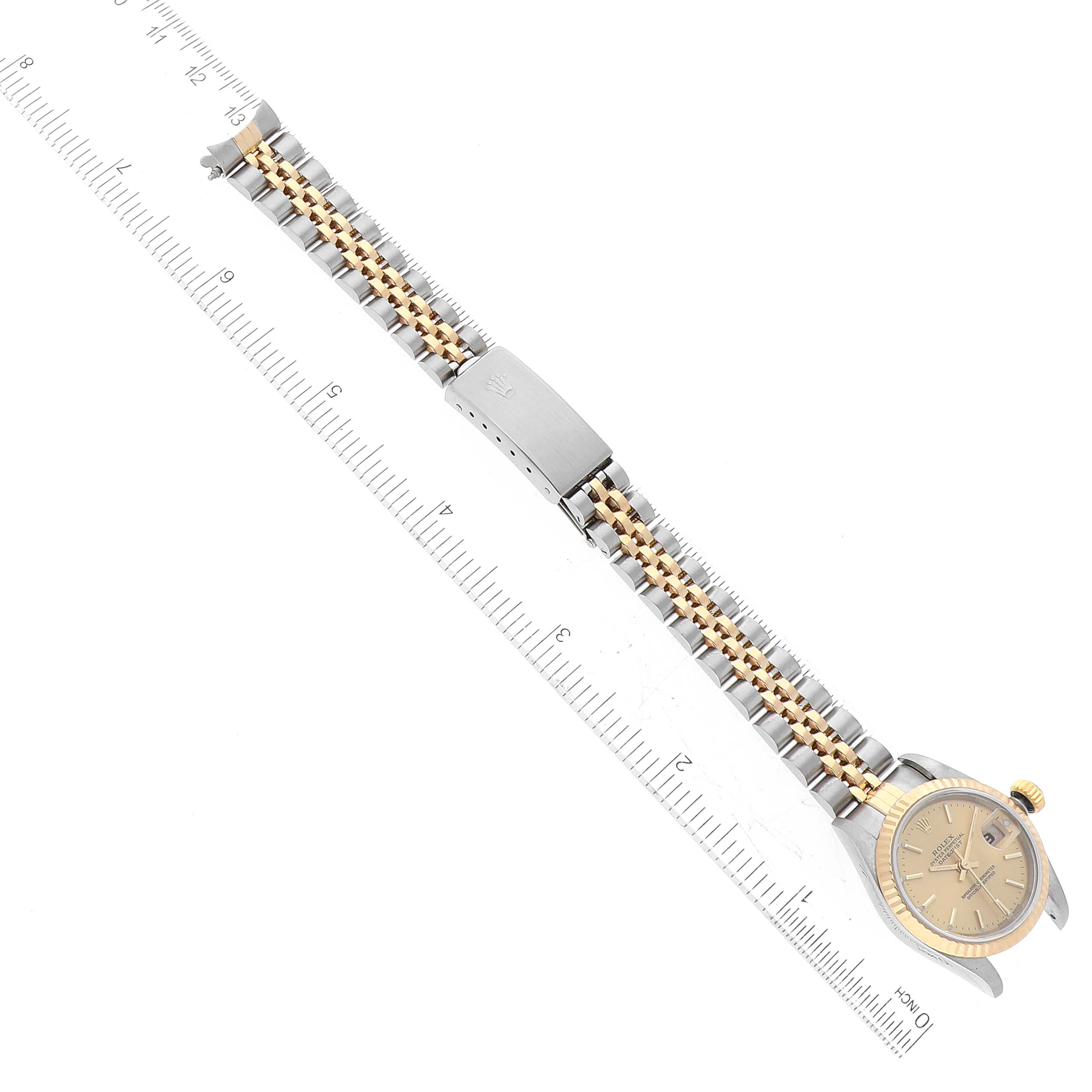This image shows a Rolex Datejust 79173 Women's Steel and Gold (two tone) Champagne Dial 79173 Women's Steel and Gold (two tone) Champagne Dial watch laid flat with a ruler for scale, highlighting the dial, crown, and full bracelet.