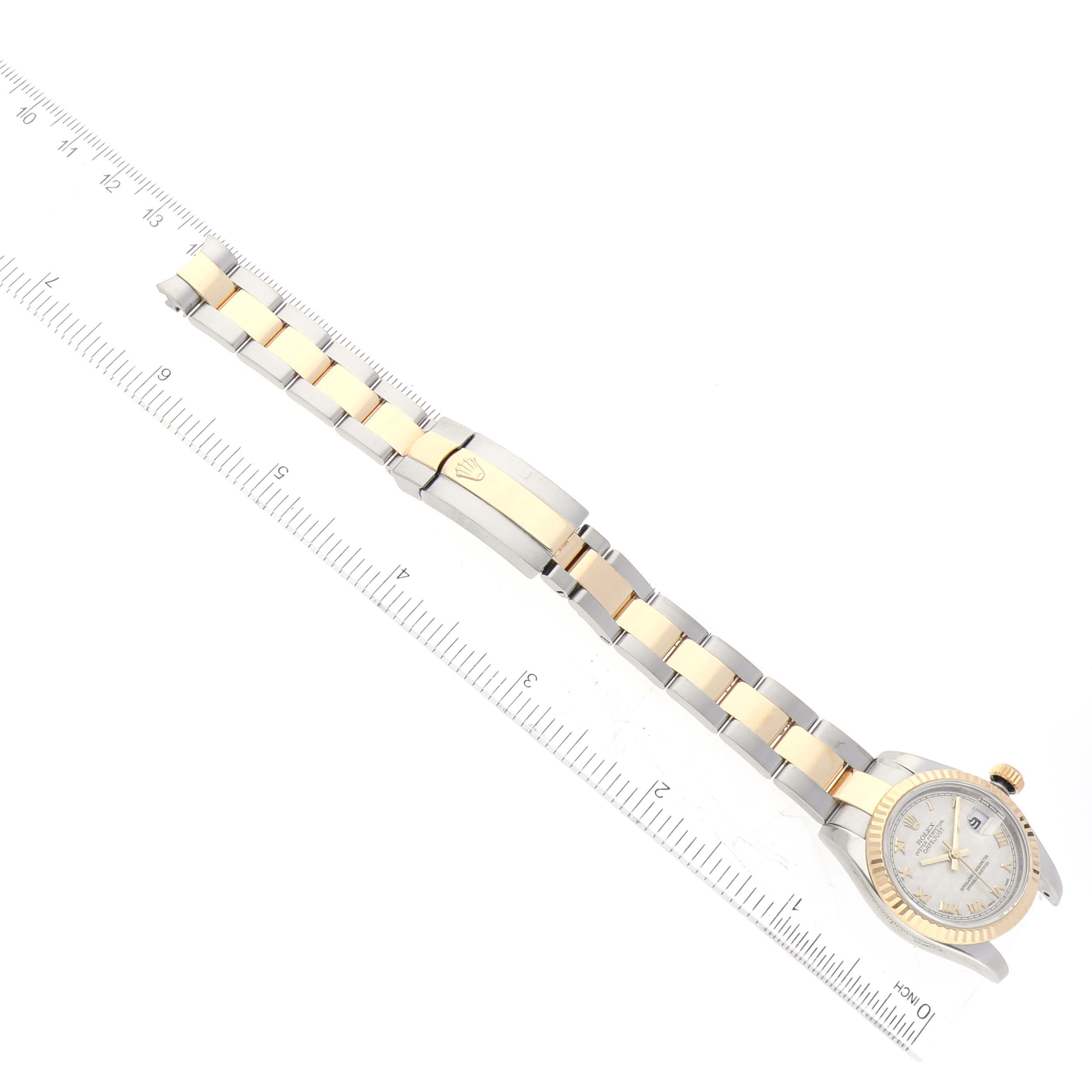 The image shows a top-down view of a Rolex Datejust 179173 Women's Steel and Gold (two tone) Beige Dial 179173 Women's Steel and Gold (two tone) Beige Dial watch, showcasing the face, bezel, crown, and Jubilee bracelet with ruler for scale.