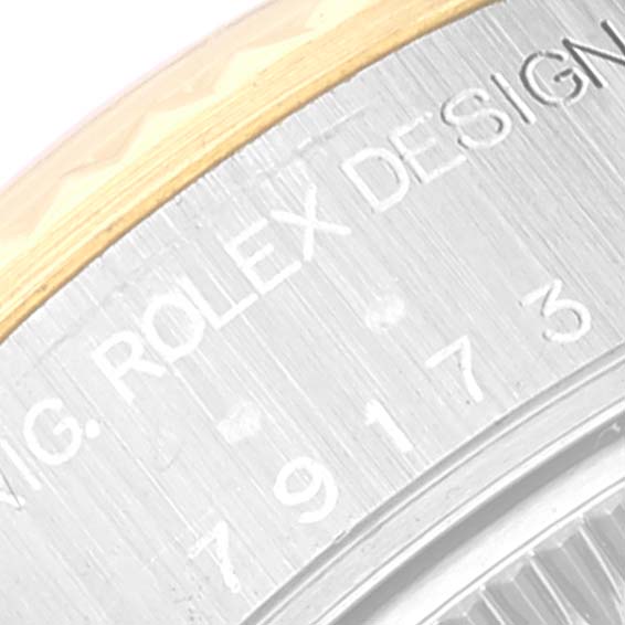 This close-up of the Rolex Datejust 79173 Women's Steel and Gold (two tone) Beige Dial 79173 Women's Steel and Gold (two tone) Beige Dial shows the engraved bezel featuring the Rolex Design text.