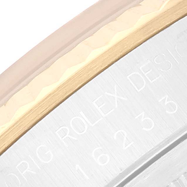 This close-up image shows the edge of the bezel and part of the caseback of a Rolex Datejust 16233 Men's Steel and Gold (two tone) Beige Dial 16233 Men's Steel and Gold (two tone) Beige Dial watch.