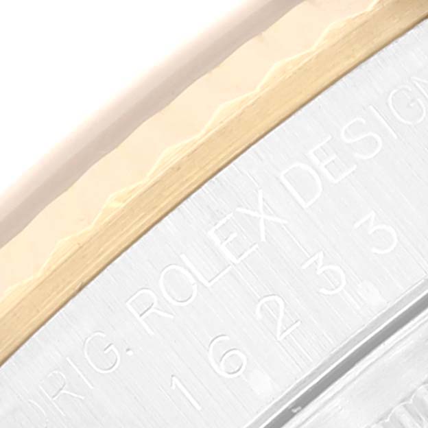 This image shows a close-up of the engraved "Rolex Design" and the fluted bezel of a Rolex Datejust 16233 Men's Steel and Gold (two tone) Blue Dial 16233 Men's Steel and Gold (two tone) Blue Dial watch.