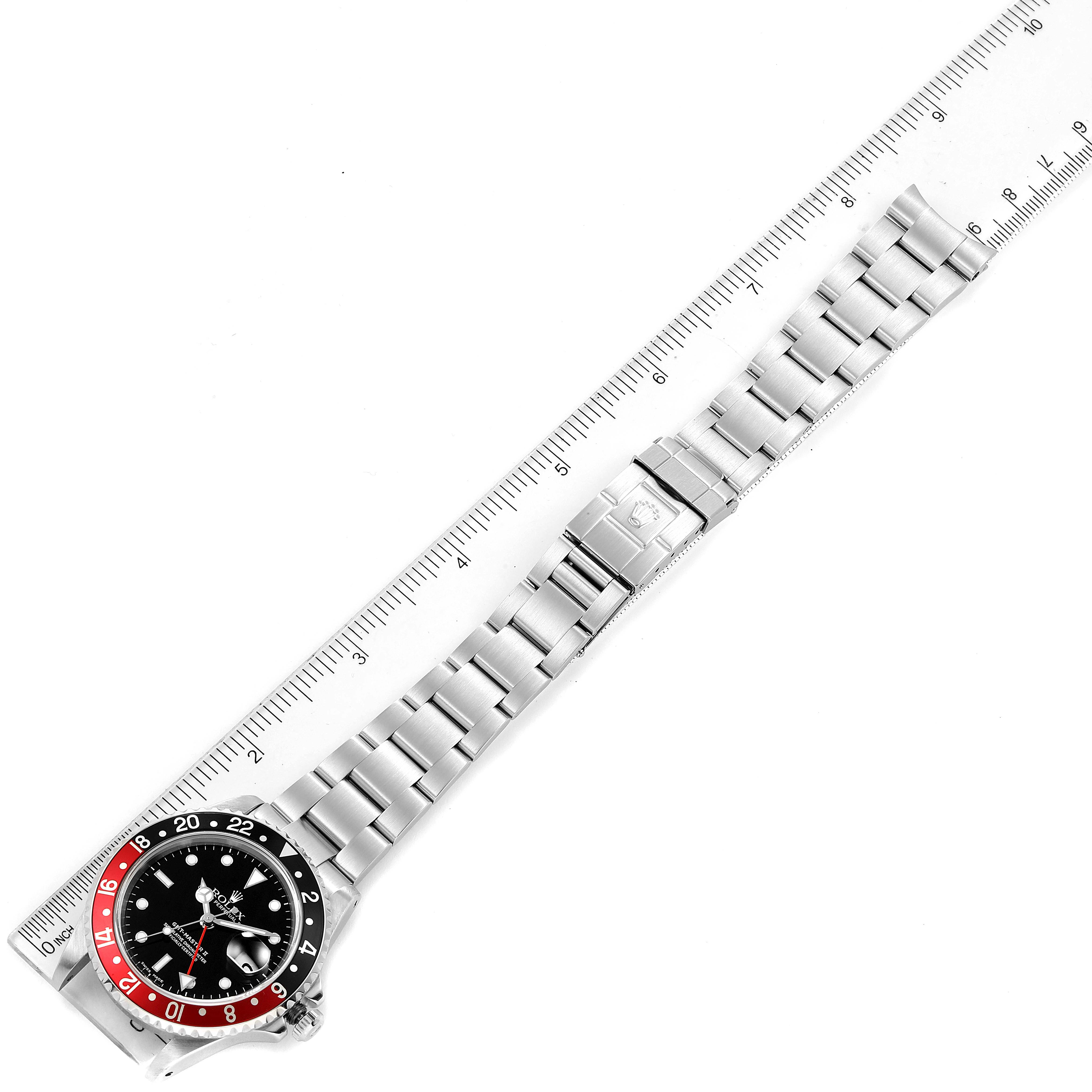 The Rolex GMT-Master 16710 Men
s Stainless Steel Black Dial 16710 Men
s Stainless Steel Black Dial watch is shown laid flat, displaying its face, bezel, and metal bracelet with a ruler for scale.