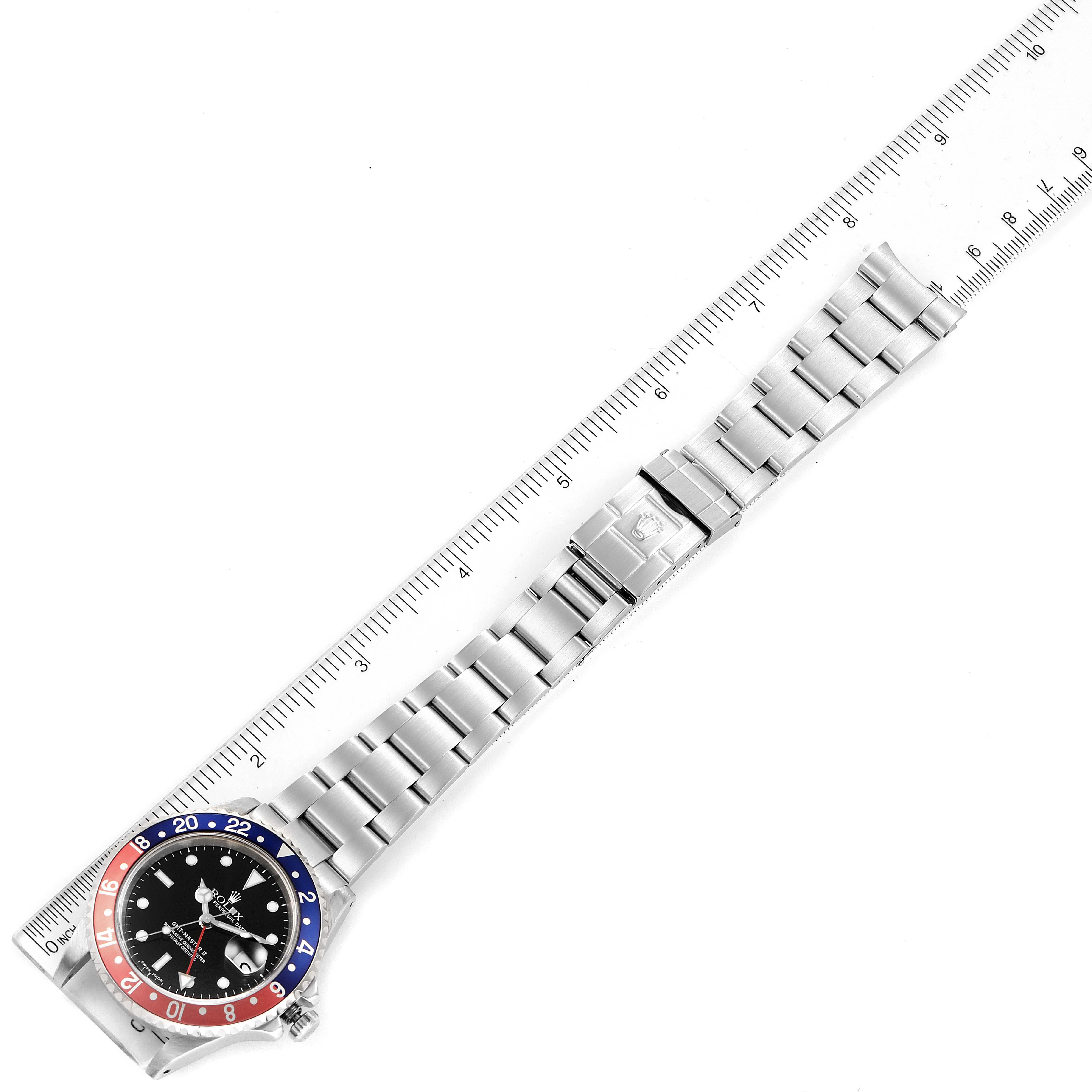 The image shows a top-down view of the Rolex GMT-Master 16710 Men
s Stainless Steel Black Dial 16710 Men
s Stainless Steel Black Dial watch, with the band laid straight next to a ruler for measurement.