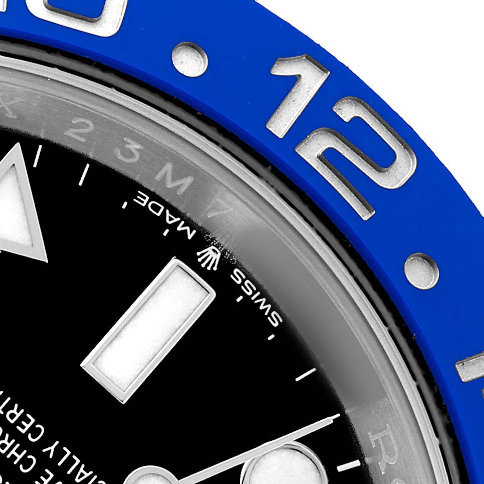 This image shows the Rolex GMT-Master 126710 Men's Stainless Steel Black Dial's bezel, dial, and part of the 12 o'clock marker at an angled close-up view.