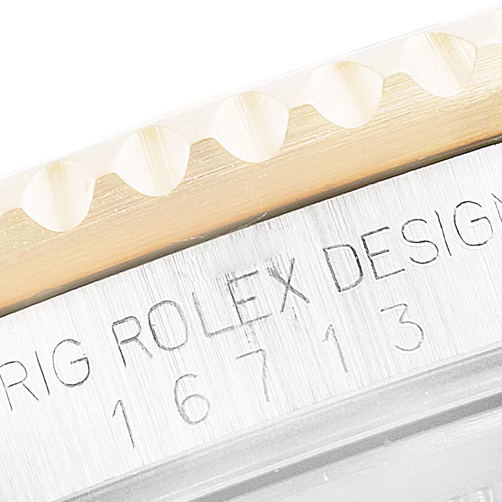 Close-up of the case side of a Rolex GMT-Master 16713 Men's Steel and Gold (two tone) Black Dial 16713 Men's Steel and Gold (two tone) Black Dial watch, showing part of the bezel and engraved reference number.