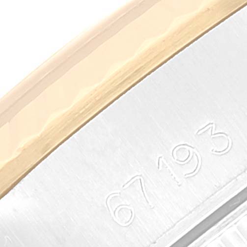 This image shows a close-up angle of the side of the Rolex Oyster Perpetual 67193 Women's Steel and Gold (two tone) Champagne Dial 67193 Women's Steel and Gold (two tone) Champagne Dial watch, displaying part of its engraved serial number.