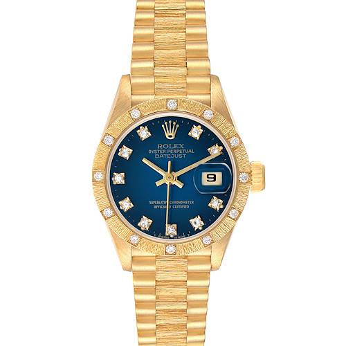 The image shows a Rolex President 69288 Women's Yellow Gold Blue Dial model from a top-down angle, highlighting the gold bracelet, blue dial, and diamond markers.
