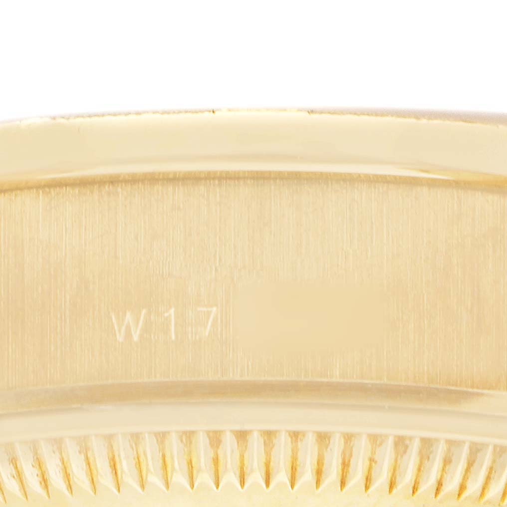 The image shows an extreme close-up of the gold fluted bezel and side of the Rolex President 69288 Women's Yellow Gold Blue Dial watch.