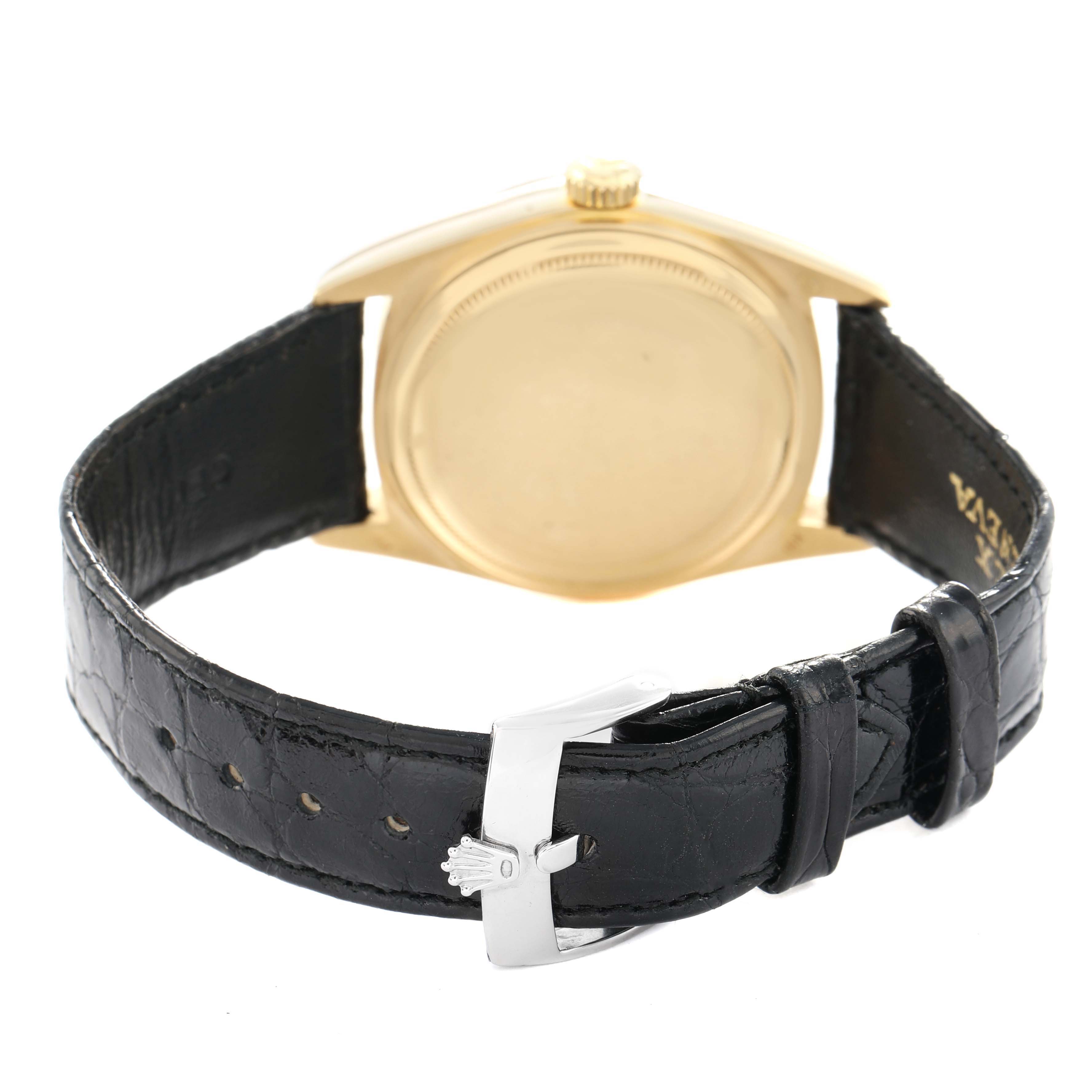 The Rolex President 18038 Men's Yellow Gold Champagne Dial watch is shown from the rear, highlighting the case back and black leather strap with a clasp.