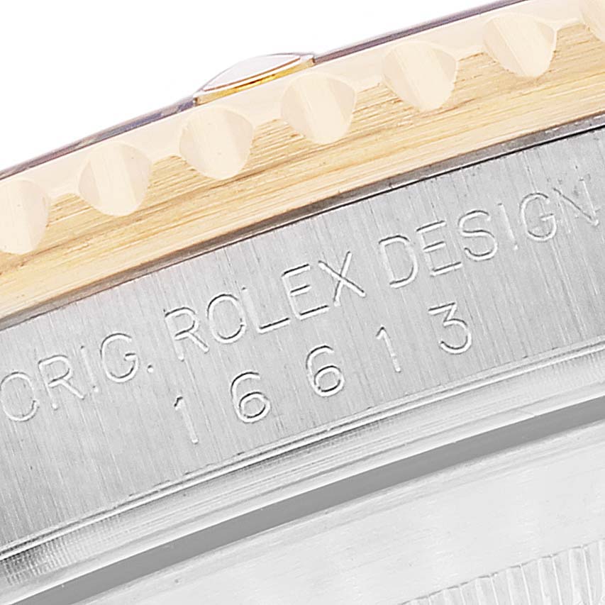 This image shows a close-up view of the bezel and case edge of a Rolex Submariner 16613 Men's Steel and Gold (two tone) Blue Dial 16613 Men's Steel and Gold (two tone) Blue Dial, highlighting its engraved model number.