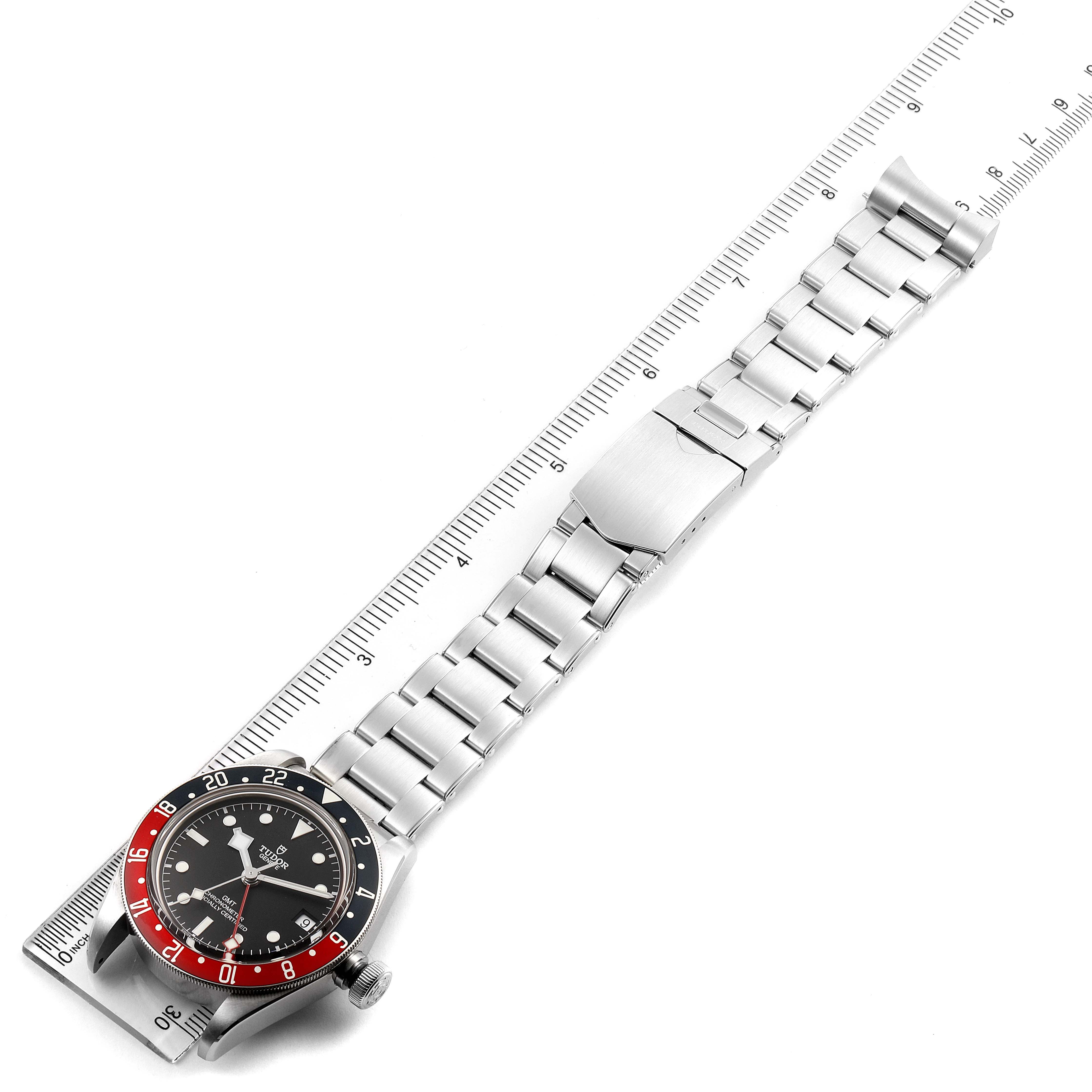 The Tudor Heritage Black Bay 79830RB Men
s Stainless Steel Black Dial 79830RB Men
s Stainless Steel Black Dial watch is shown flat, displaying its face, bezel, and stainless steel bracelet alongside a ruler.