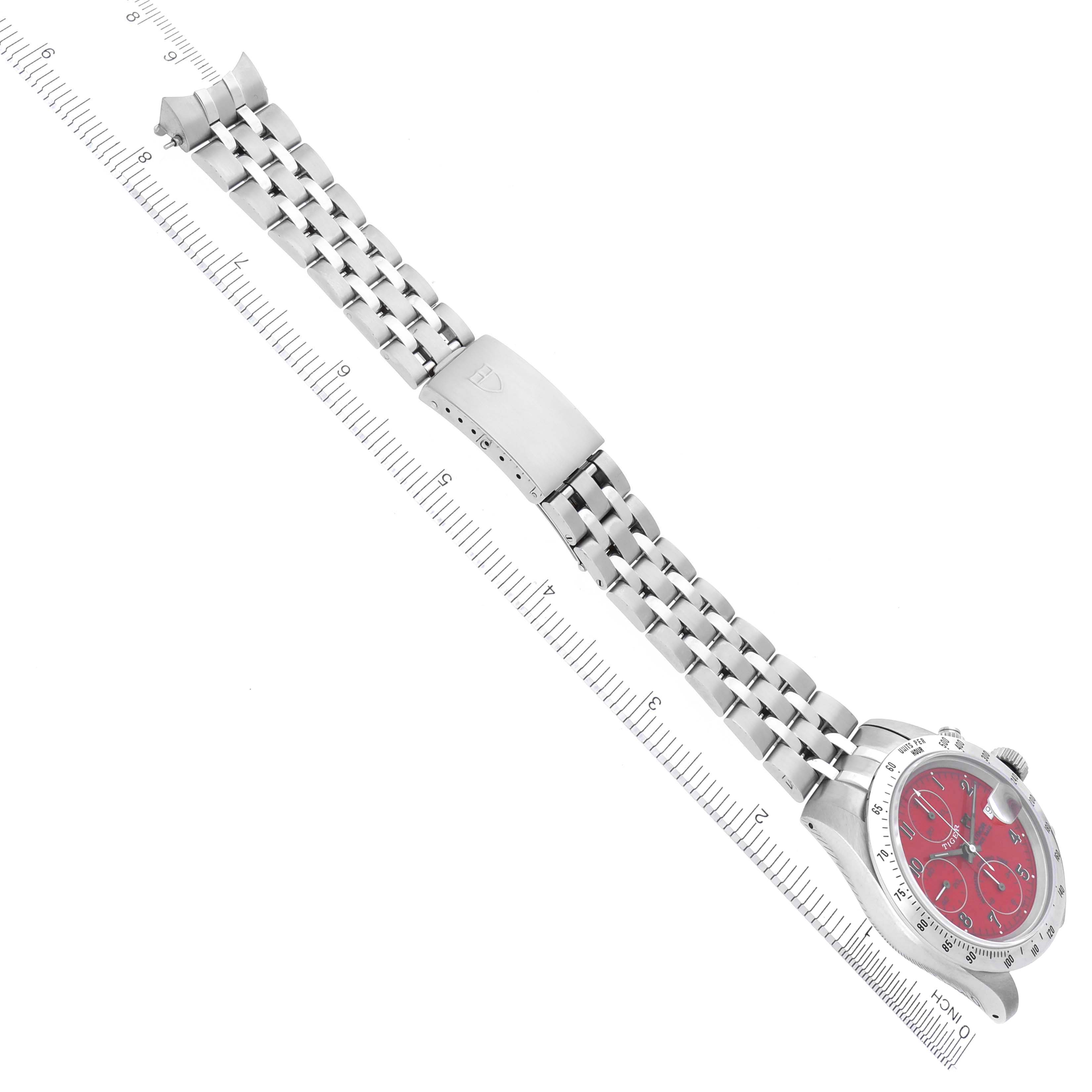 The Tudor Tiger 79280 Men's Stainless Steel Red Dial 79280 Men's Stainless Steel Red Dial watch is shown from a side angle, highlighting its bracelet and red dial with a ruler for scale.