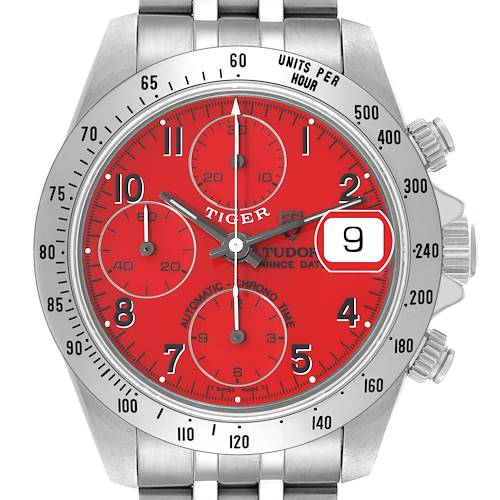 The Tudor Tiger watch is shown from the front, displaying the red dial, chrono dials, date window, and bezel markings.