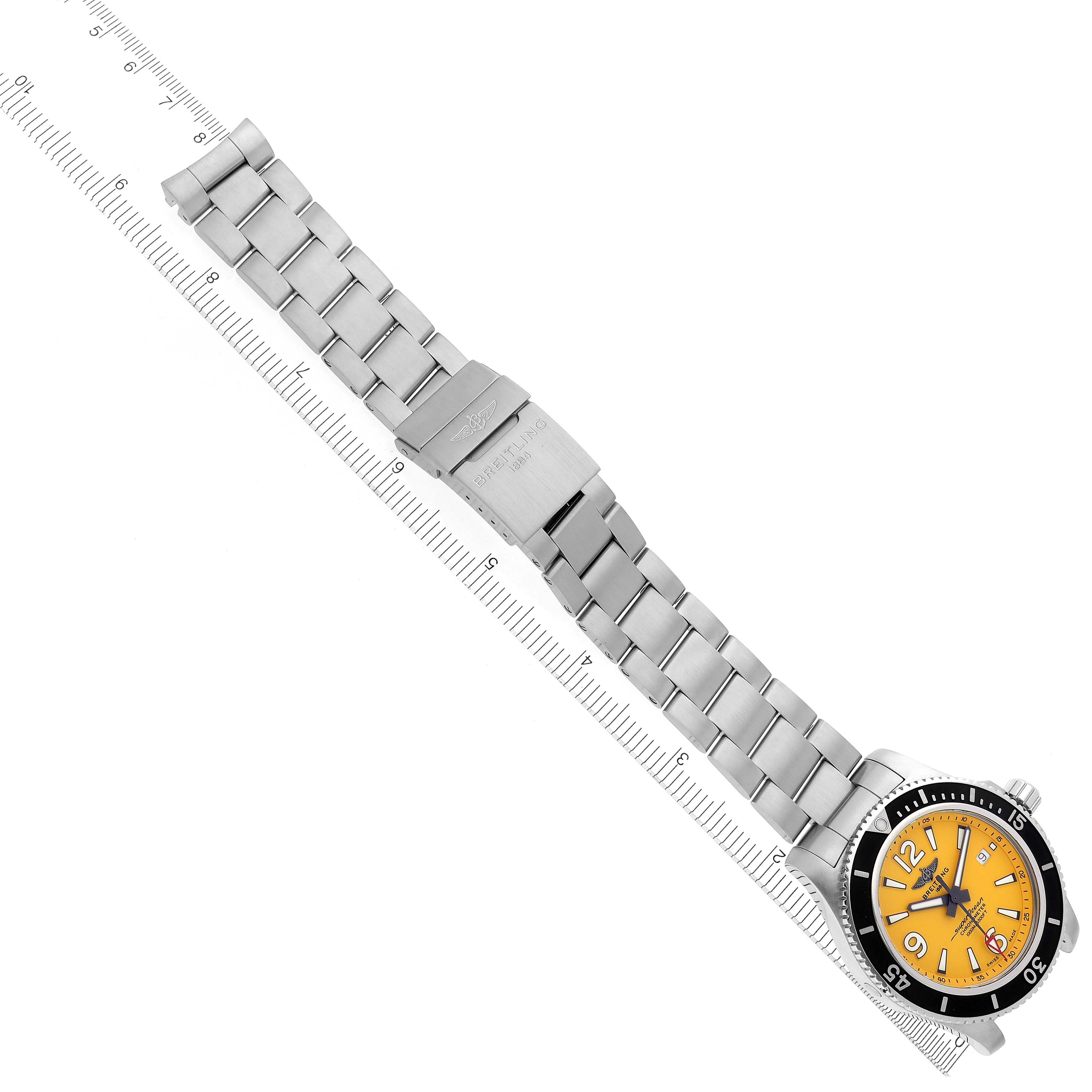 The Breitling Superocean A17367 Men
s Stainless Steel Yellow Dial A17367 Men
s Stainless Steel Yellow Dial watch is shown at an angle, highlighting the yellow dial, bezel, and full metal bracelet with a ruler for scale.