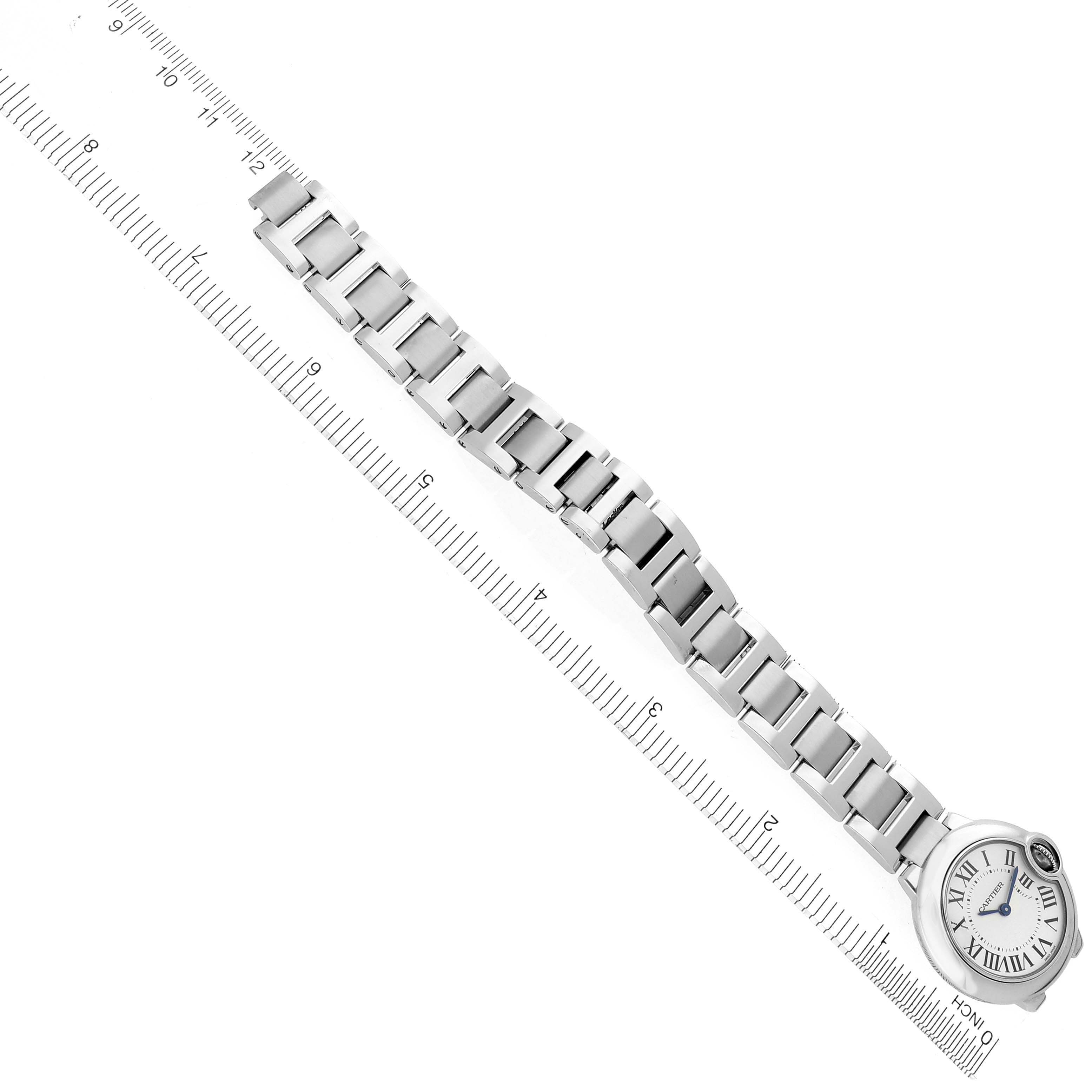 The image shows the Ballon Bleu by Cartier from an oblique angle, highlighting its bracelet and dial against a measuring ruler.