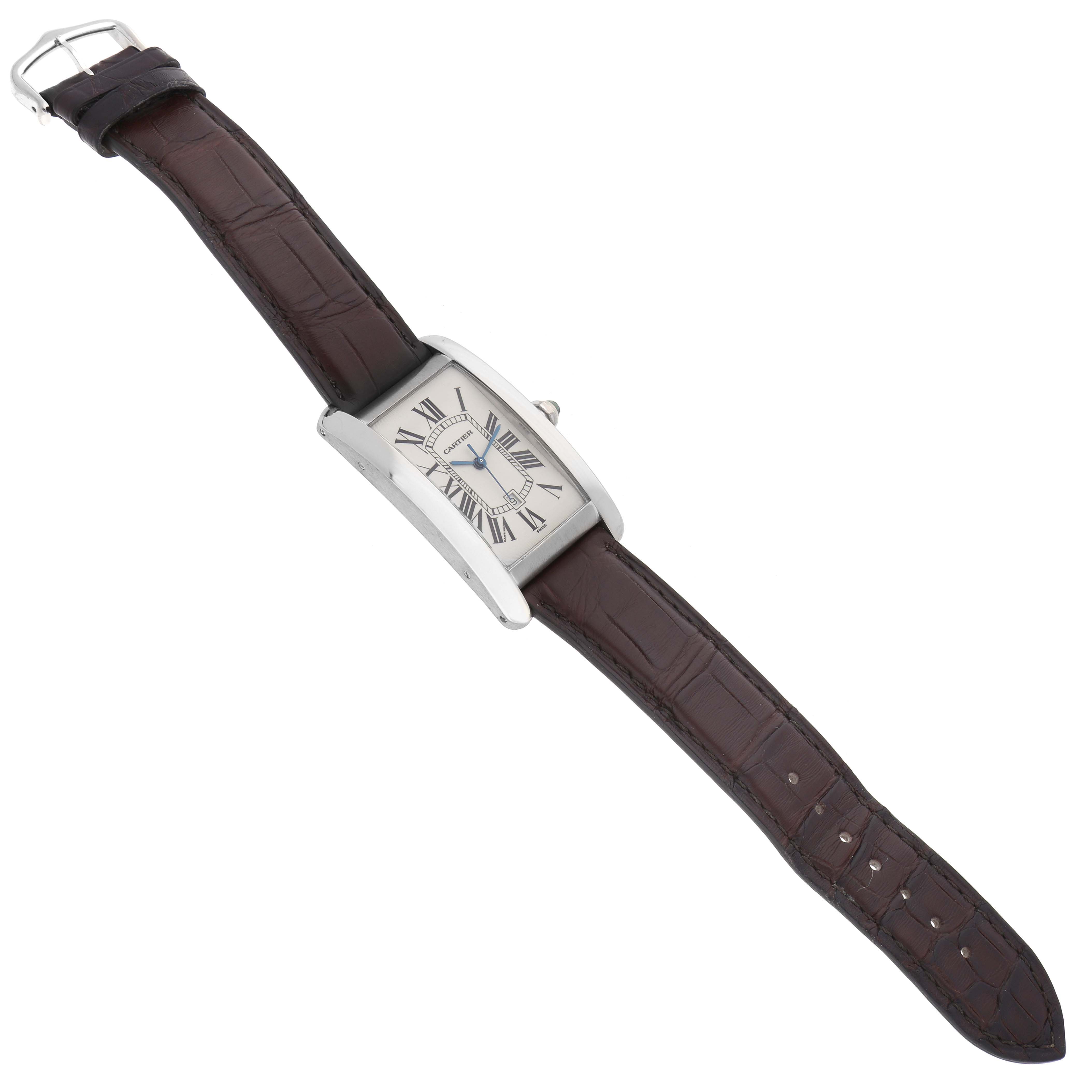 The Cartier Tank Américaine watch is shown from a top angle, highlighting the rectangular face and brown leather strap.