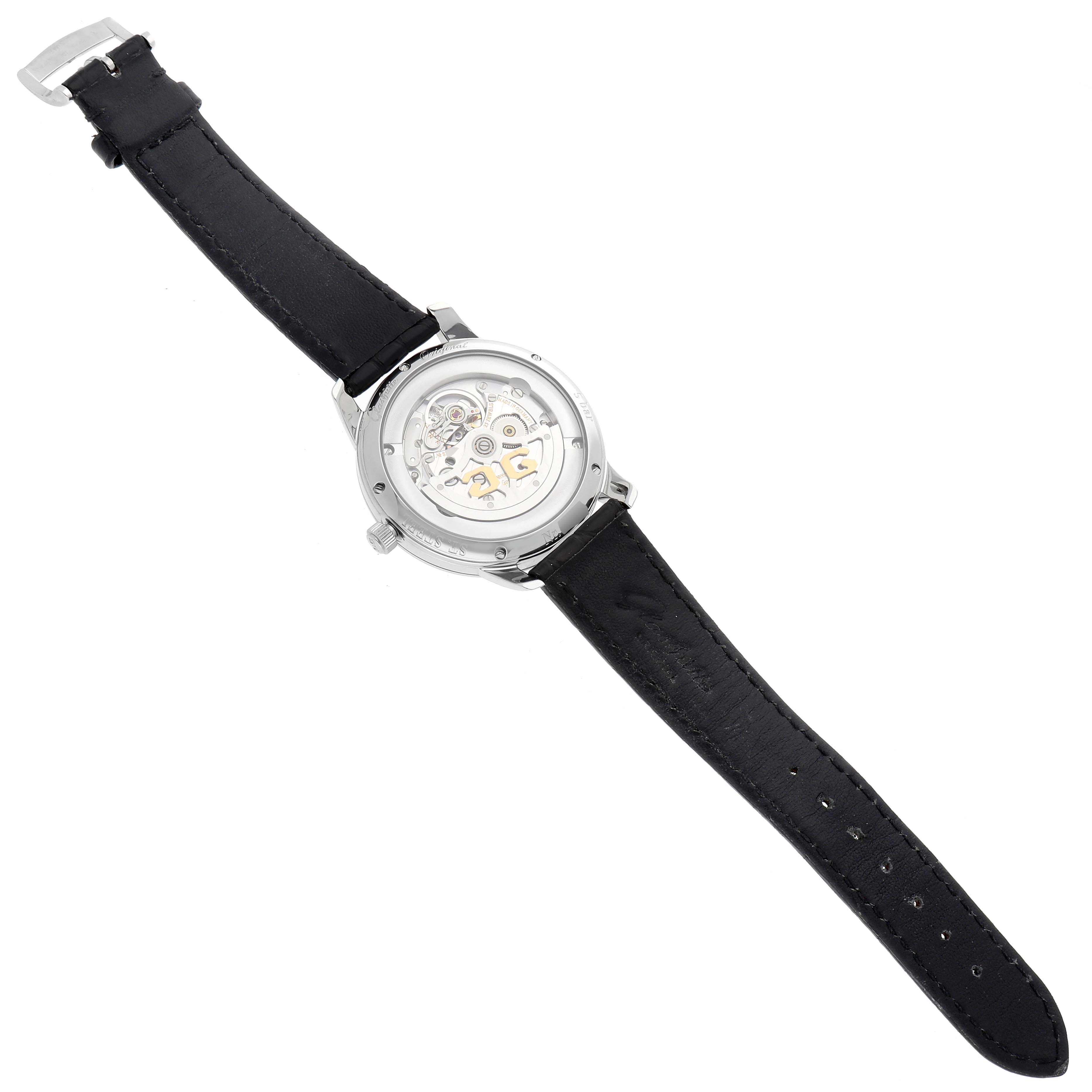 The Glashütte Original watch is shown from the back, displaying the transparent case back and movement with a black leather strap.