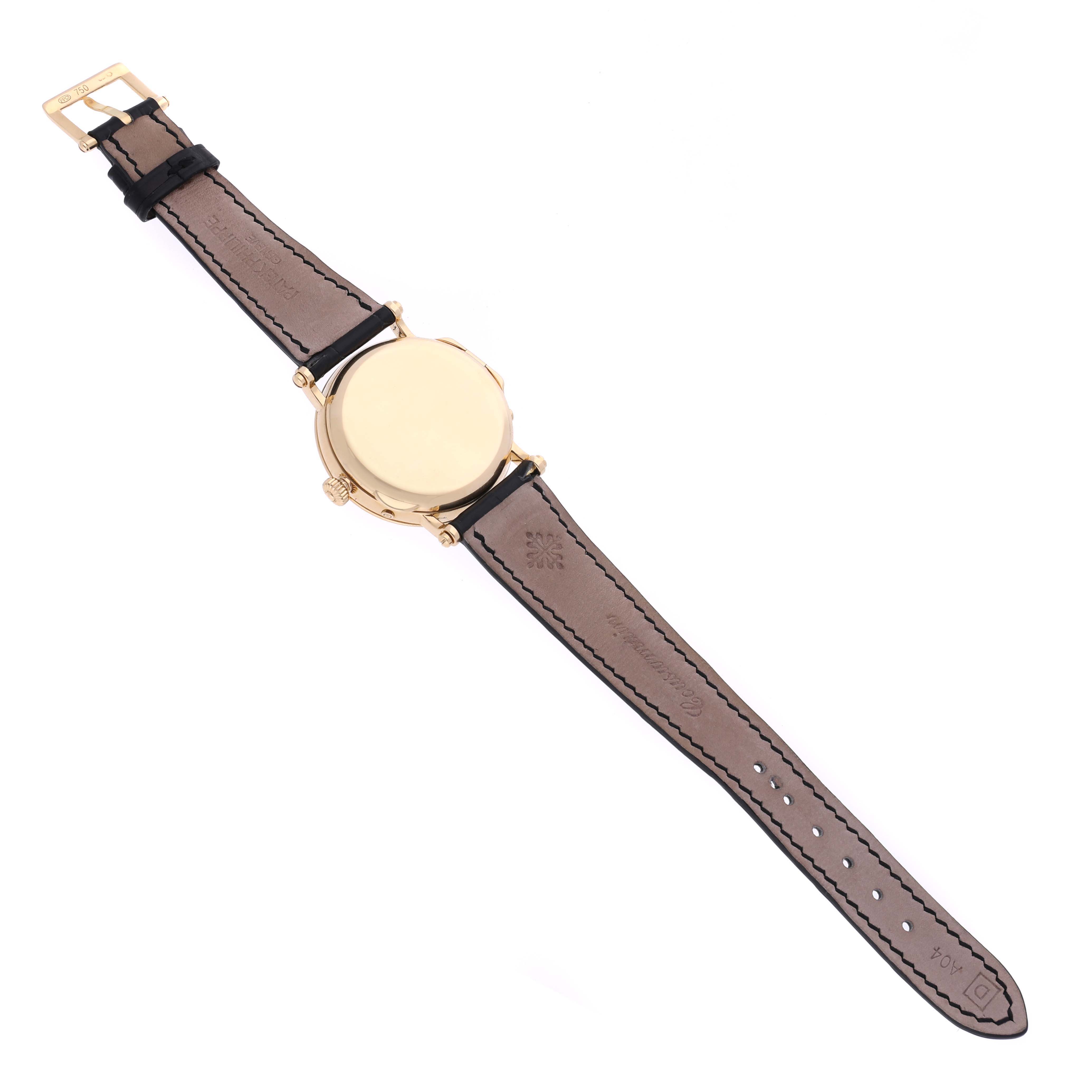 The image shows the back and strap of a Patek Philippe Complications 5054 Men's Yellow Gold White Dial 5054 Men's Yellow Gold White Dial watch from a top-down angle.