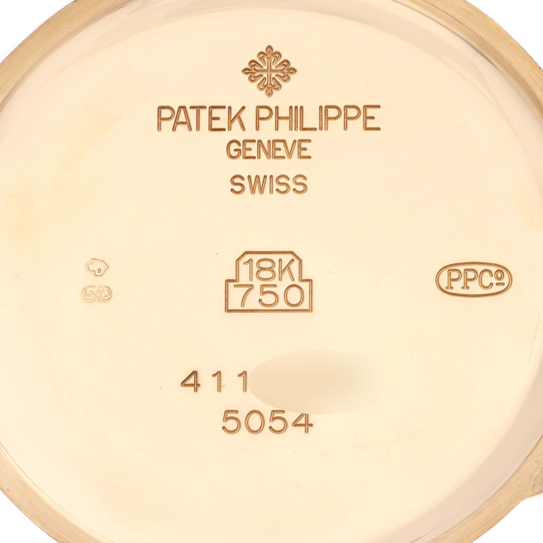 The image shows the inside of the case back of a Patek Philippe Complications 5054 Men's Yellow Gold White Dial 5054 Men's Yellow Gold White Dial watch, highlighting the gold markings and hallmarks.