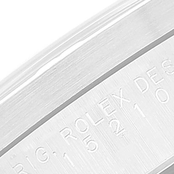 This close-up image shows the edge of a Rolex Date 15210 Men
s Stainless Steel Blue Dial 15210 Men
s Stainless Steel Blue Dial model, showcasing part of the engraved lettering.