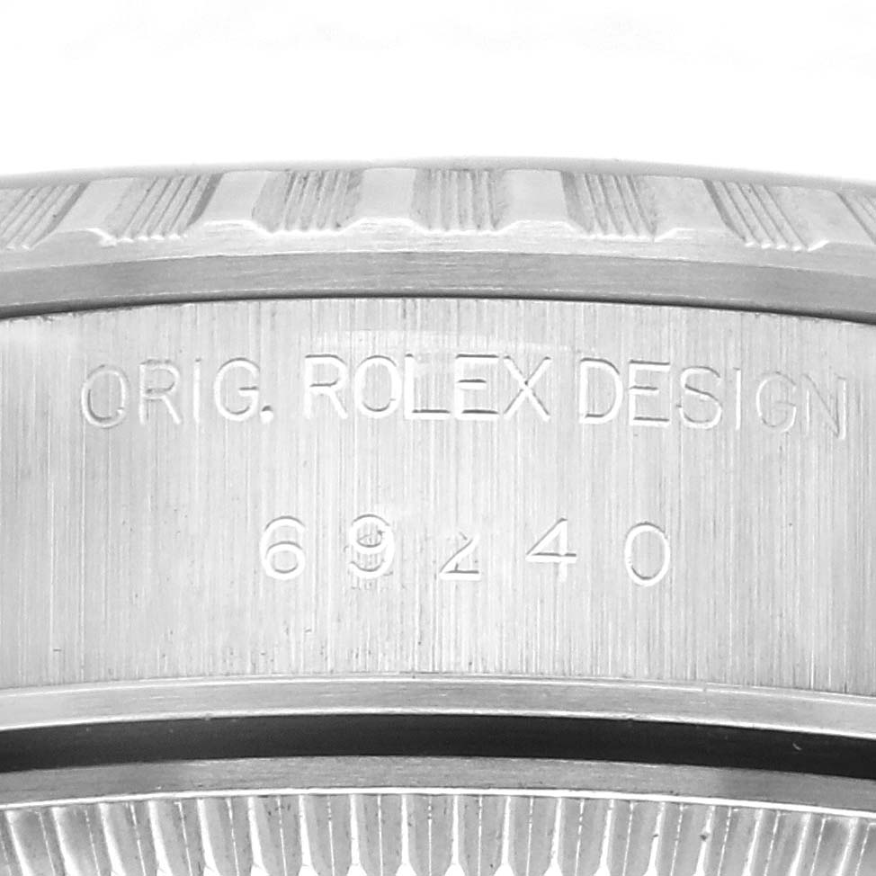 The image shows a close-up of the side of a Rolex Date 69240 Women's Stainless Steel Silver Dial 69240 Women's Stainless Steel Silver Dial model, highlighting the engraved serial and model numbers.