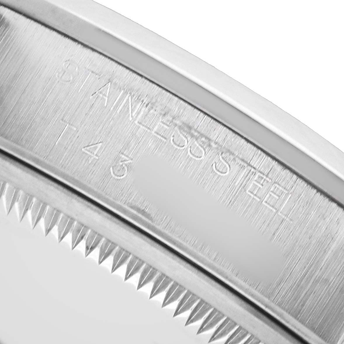 The image shows a close-up of the bezel and inner engraving on a Rolex Date 15200 Men's Stainless Steel Pink Dial model, emphasizing the "STAINLESS STEEL" text.