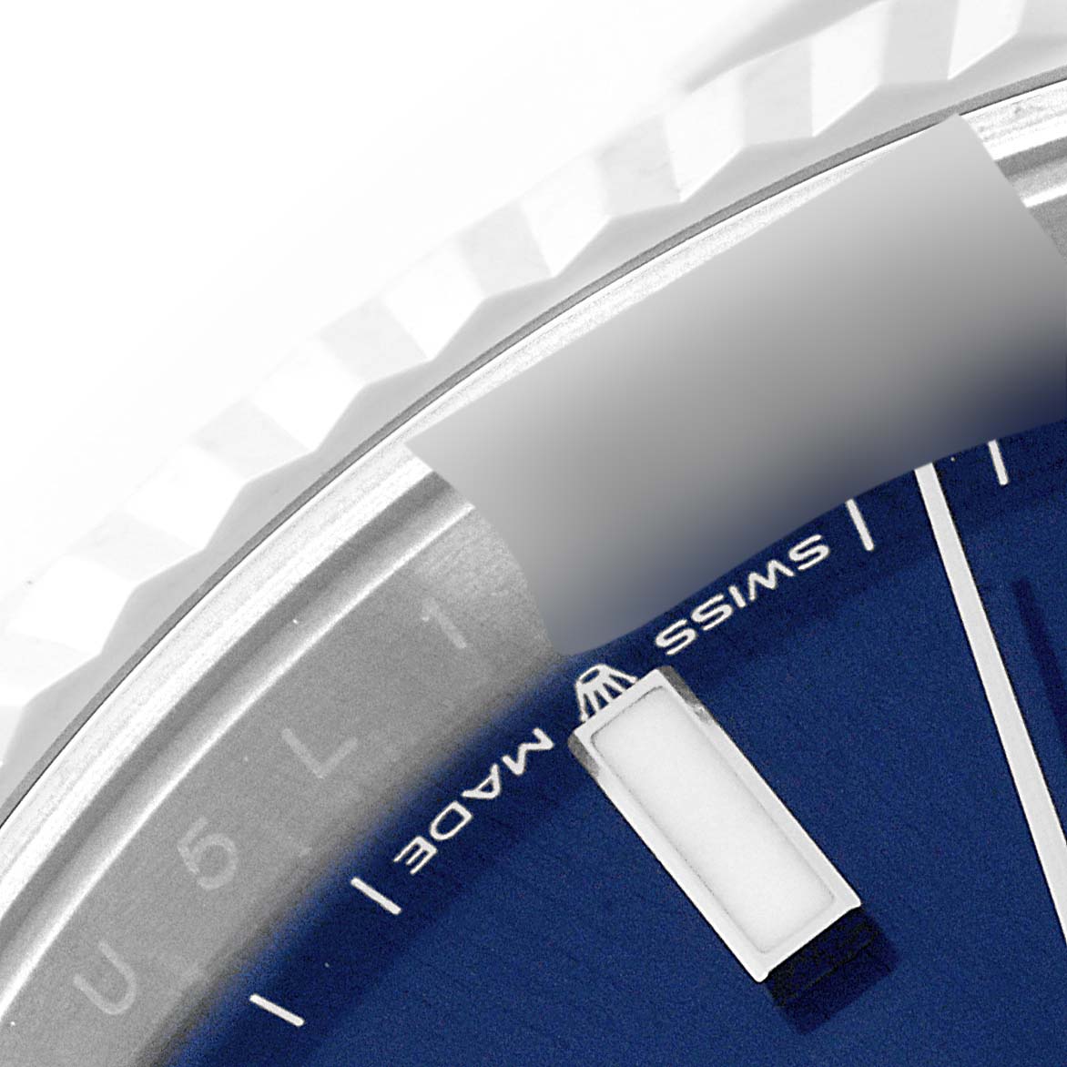This close-up image shows the fluted bezel and part of the blue dial of a Rolex Datejust 41 126334 Men's Stainless Steel Blue Dial 126334 Men's Stainless Steel Blue Dial, including the "Swiss Made" label.