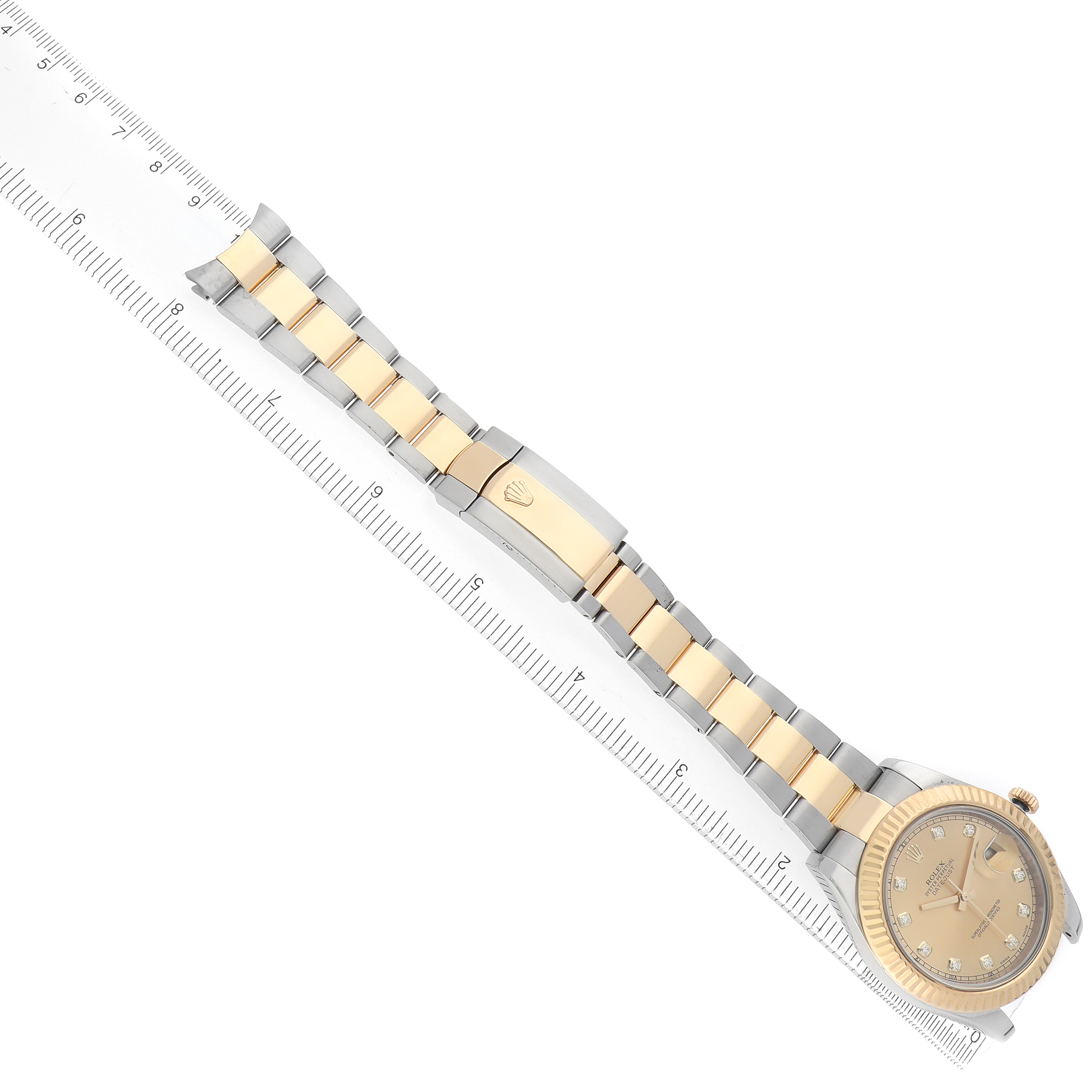 The Rolex Datejust 41 116333 Men's Steel and Gold (two tone) Champagne Dial is shown at a diagonal angle displaying the bracelet, clasp, and watch face alongside a ruler for scale.