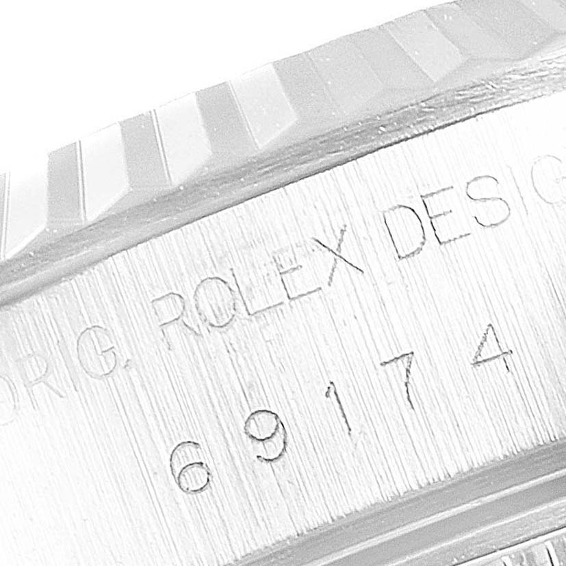 The image shows a close-up side view of the case and fluted bezel of a Rolex Datejust 69174 Women
s Stainless Steel Pink Dial 69174 Women
s Stainless Steel Pink Dial, revealing the model number and "Rolex Design" engraving.