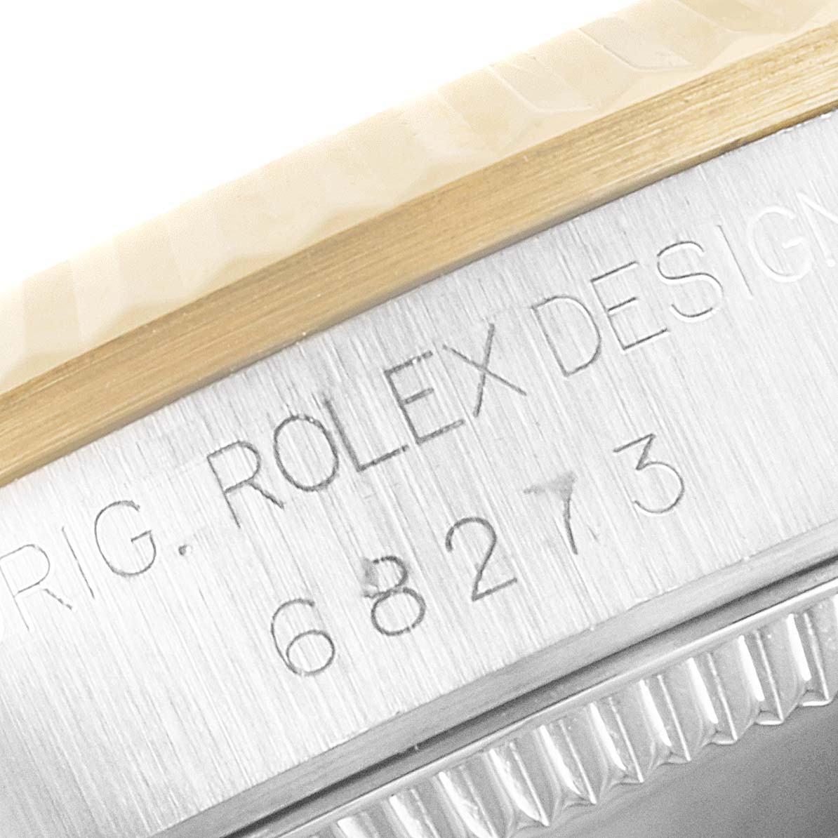 This image shows a close-up angle of the side of a Rolex Mid-Size 68273 Women
s Steel and Gold (two tone) White Dial 68273 Women
s Steel and Gold (two tone) White Dial model, highlighting the engraved serial number and part of the bezel.