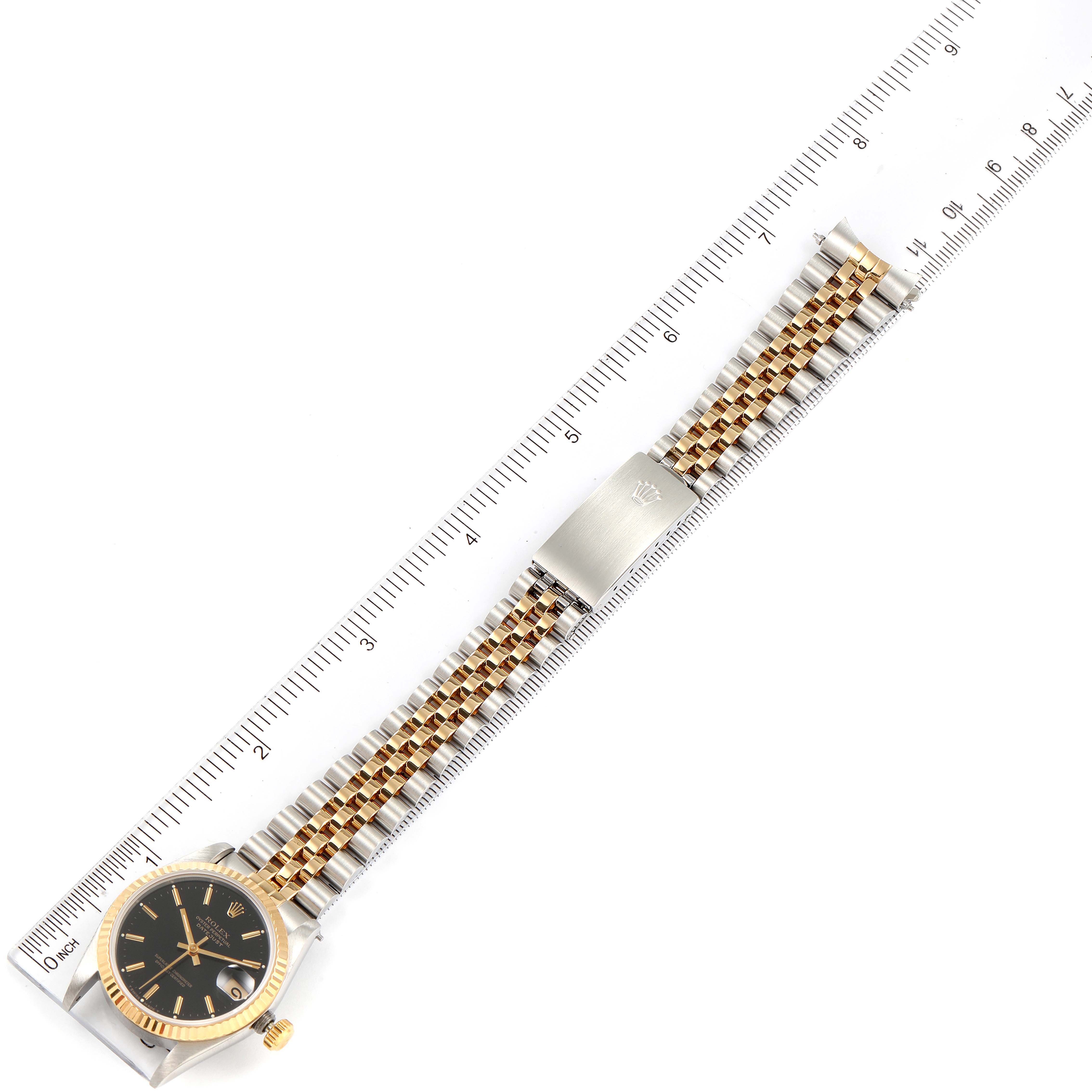 The image shows a Mid-Size Rolex watch laid flat, with the watch face, bracelet, and clasp visible, aligned with a ruler.