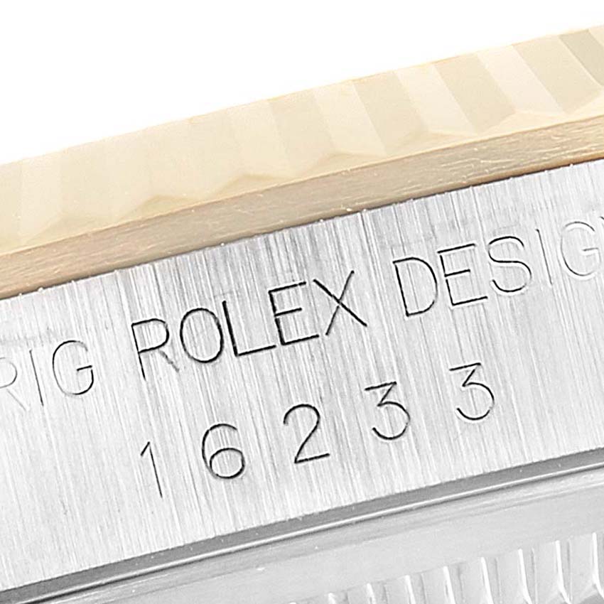 This image shows a close-up of the serial number and fluted bezel of a Rolex Datejust 16233 Men's Steel and Gold (two tone) Black Dial 16233 Men's Steel and Gold (two tone) Black Dial watch.