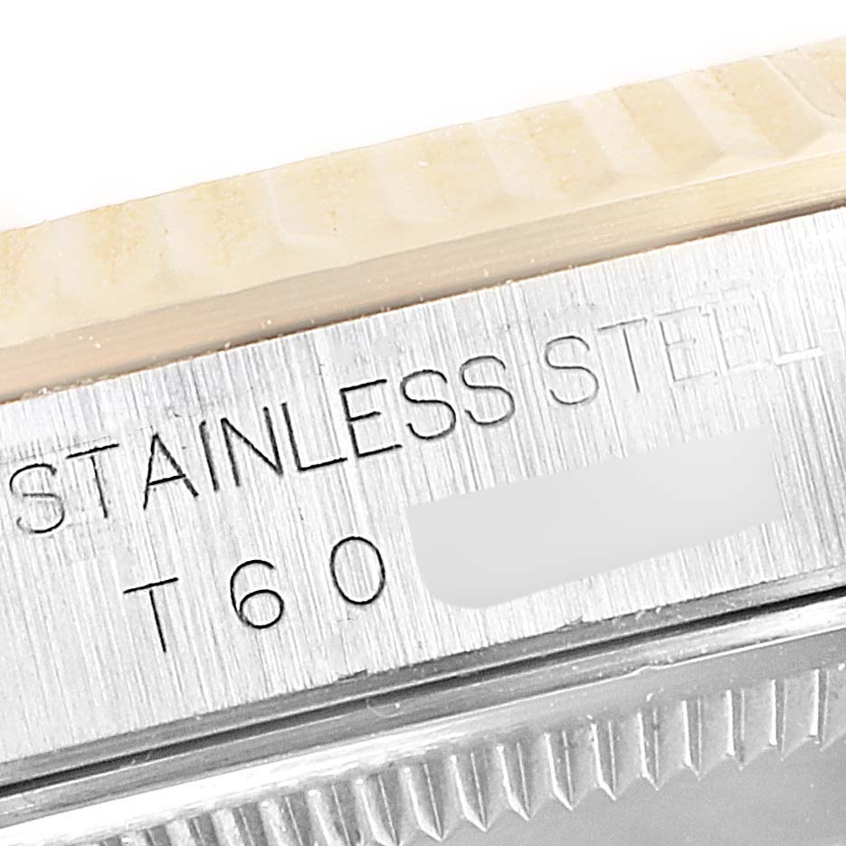 This close-up image shows the engraved serial details on the case side of a Rolex Datejust 16233 Men's Steel and Gold (two tone) Black Dial 16233 Men's Steel and Gold (two tone) Black Dial watch. 