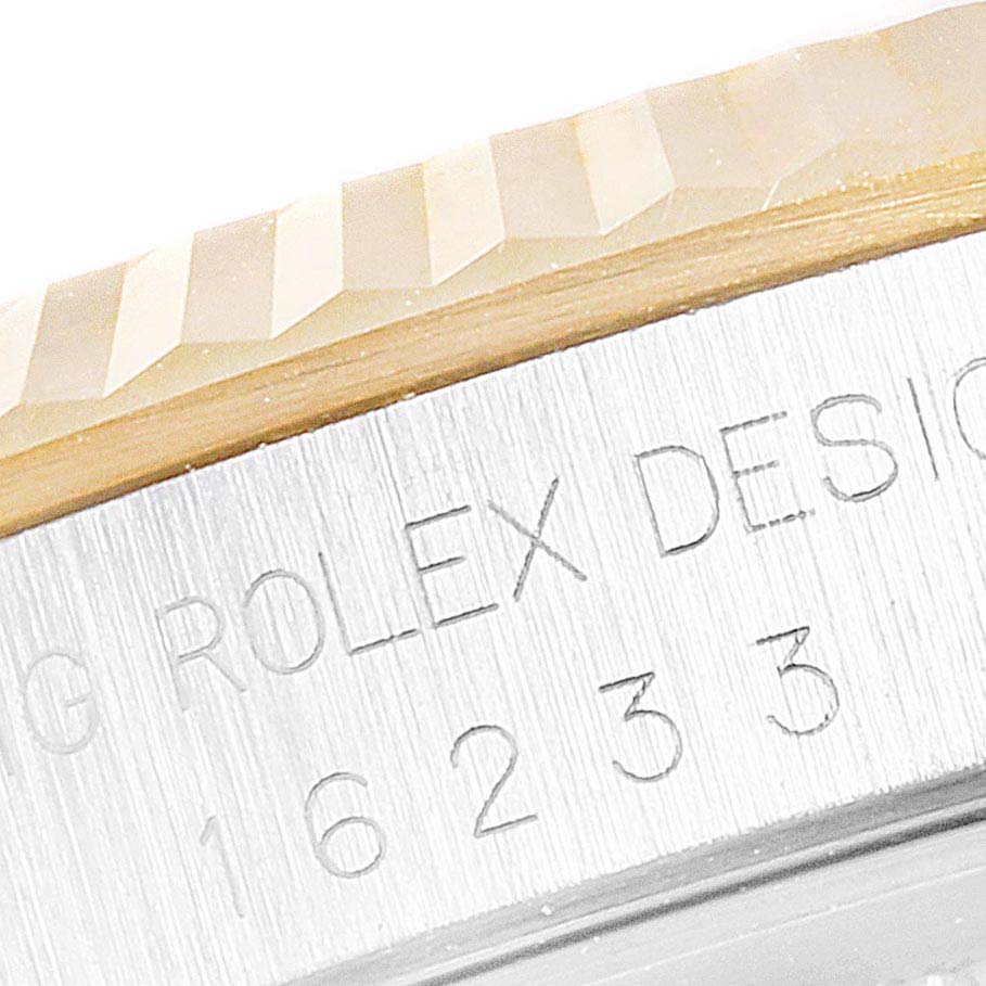 The image shows a close-up of the engraved case side and fluted bezel of the Rolex Datejust 16233 Men's Steel and Gold (two tone) Silver Dial 16233 Men's Steel and Gold (two tone) Silver Dial watch.