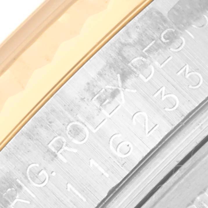 The image shows a close-up of the side engraving and bezel of a Rolex Datejust 116233 Men
s Steel and Gold (two tone) Champagne Dial 116233 Men
s Steel and Gold (two tone) Champagne Dial watch.