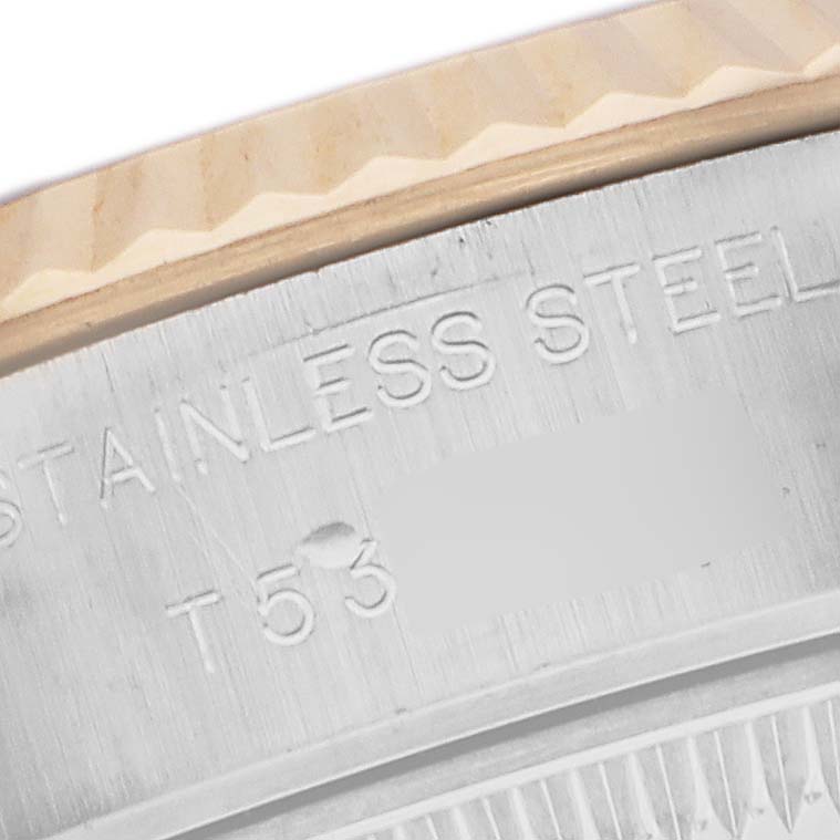 The image shows a close-up of the fluted bezel and steel case back of a Rolex Datejust 69173 Women's Steel and Gold (two tone) Black Dial watch, with "STAINLESS STEEL" engraved.