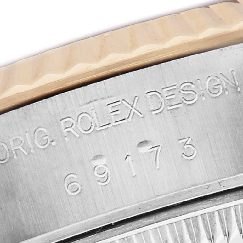 The image shows a close-up of the side of a Rolex Datejust 69173 Women's Steel and Gold (two tone) Black Dial, focusing on the bezel and engraved case edge.