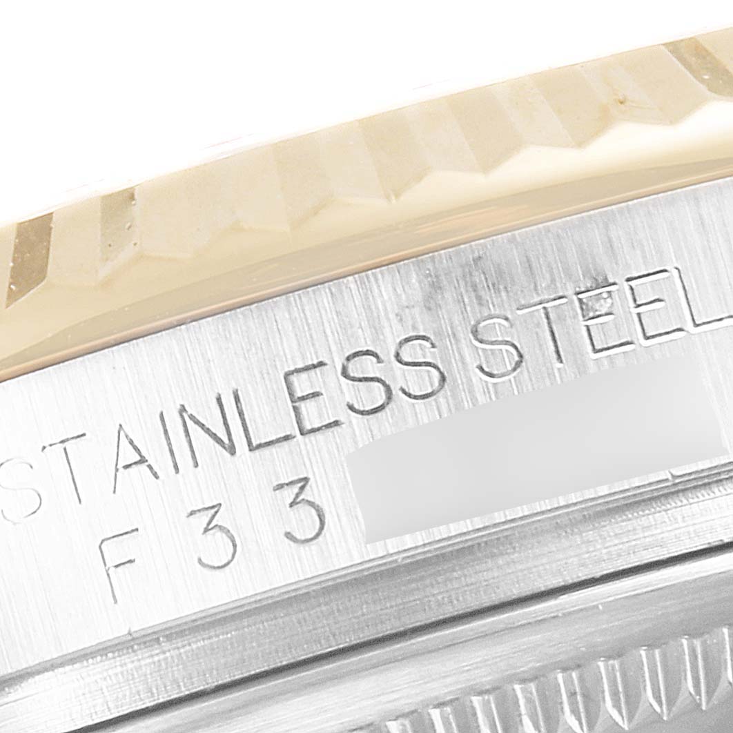 Close-up of the case side and part of the bezel of a Rolex Datejust 116233 Men's Steel and Gold (two tone) Black Dial 116233 Men's Steel and Gold (two tone) Black Dial watch, showing "STAINLESS STEEL" engraving.